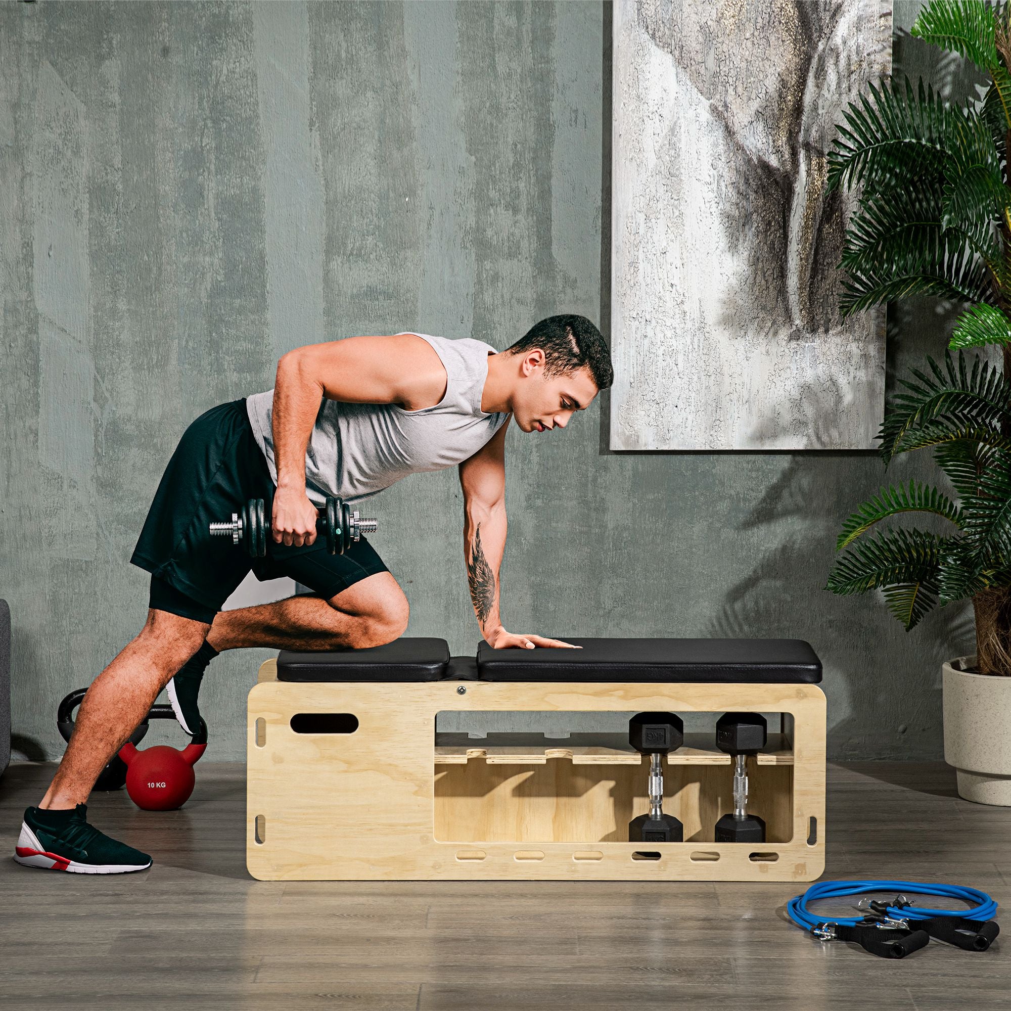 Man exercising with a wooden box and dumbbells in a home setting.