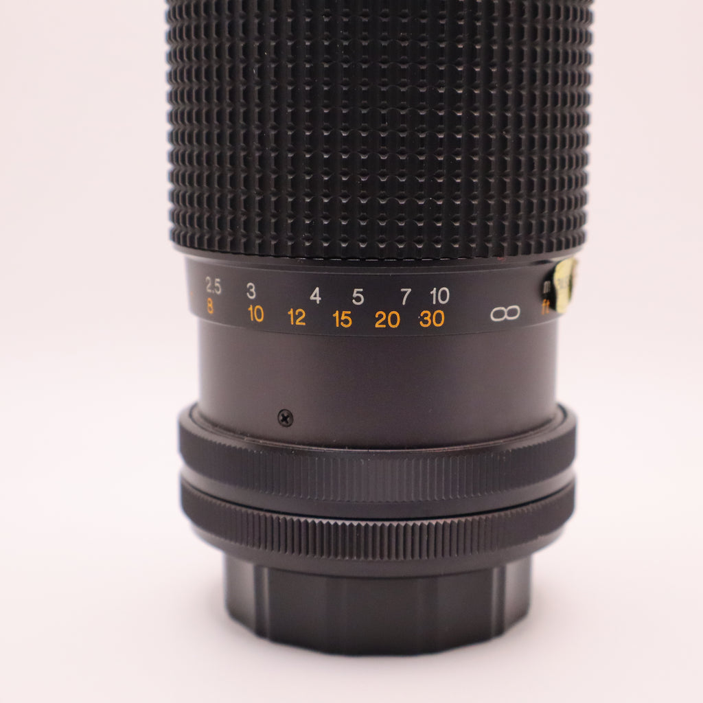 Close-up of a camera lens with focus scale on a white background