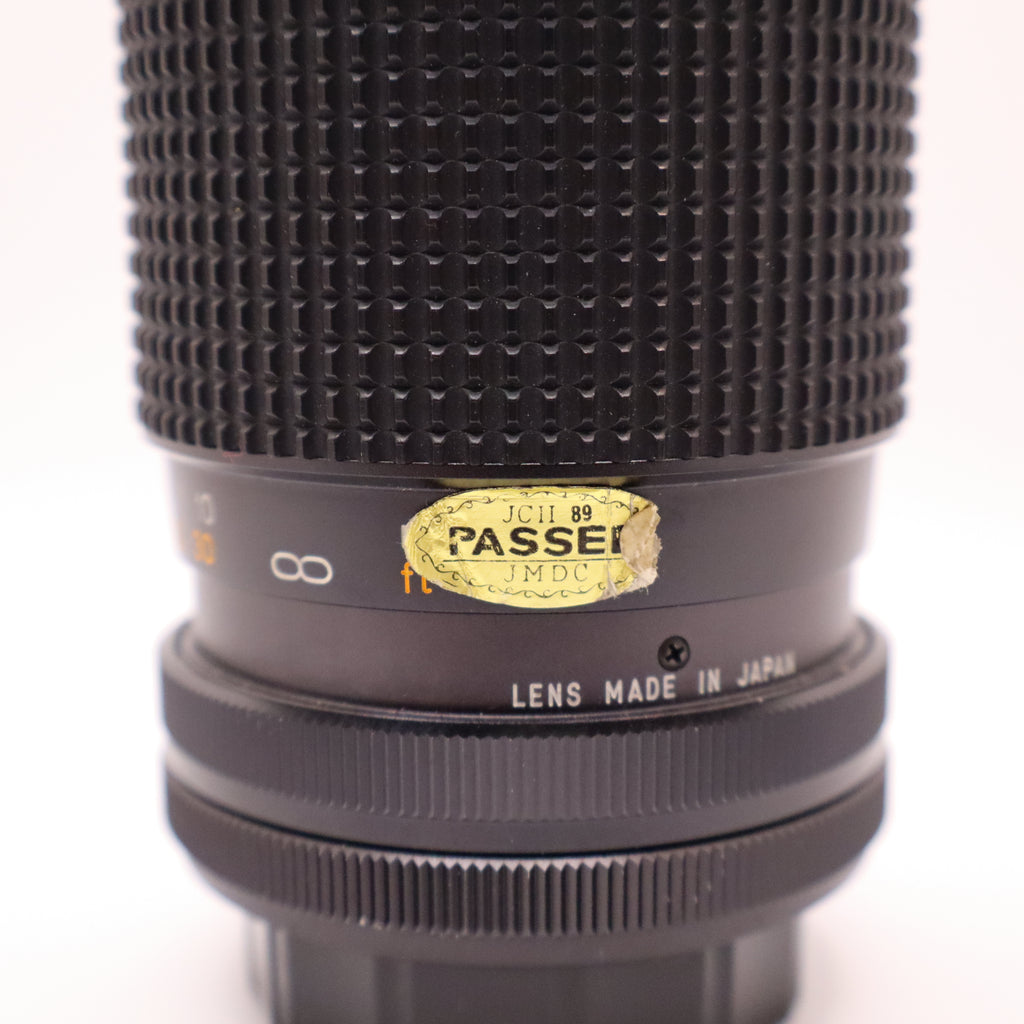Close-up of a camera lens with 'Passei' branding on a white background