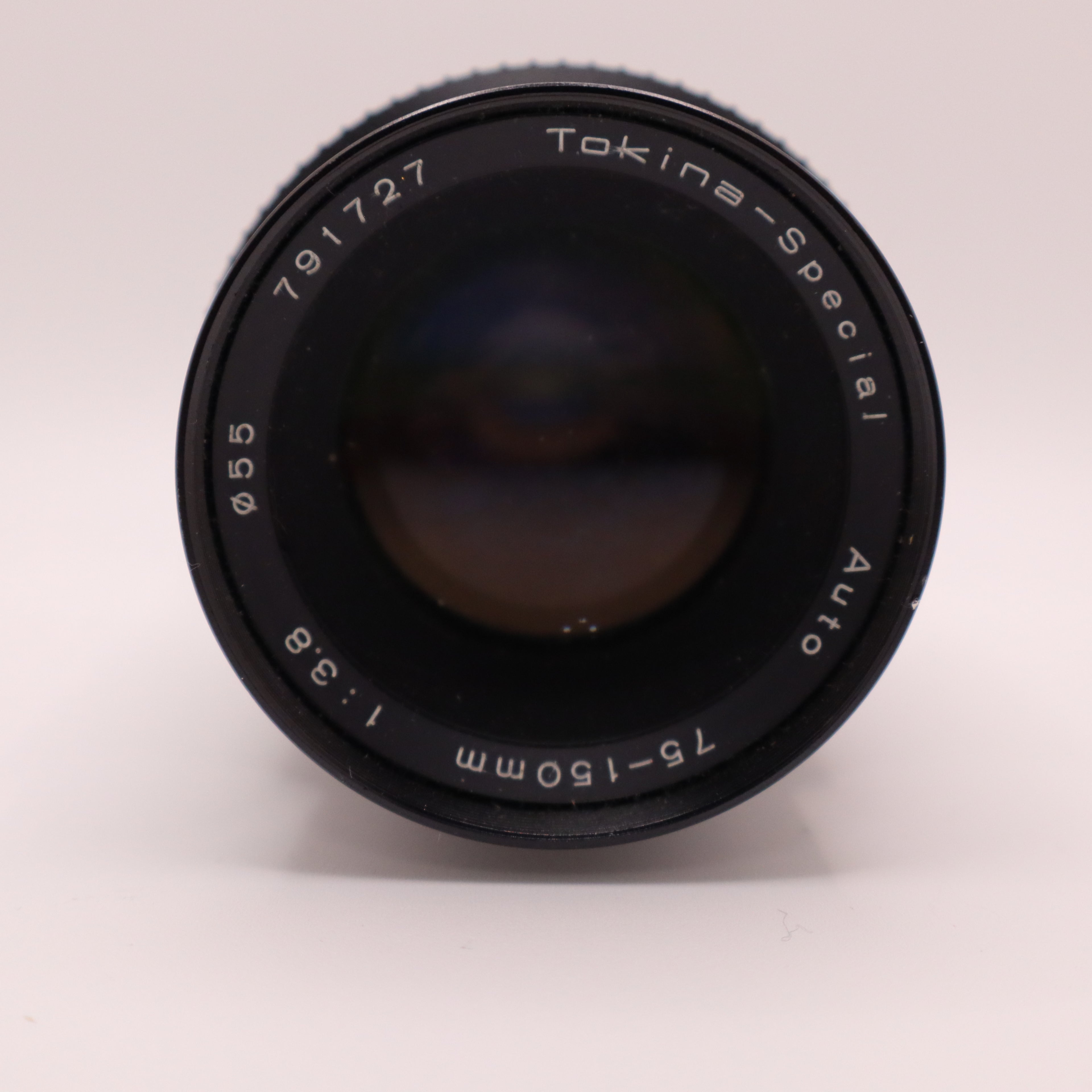 Camera lens with 'Tokina Special' branding on a light gray background