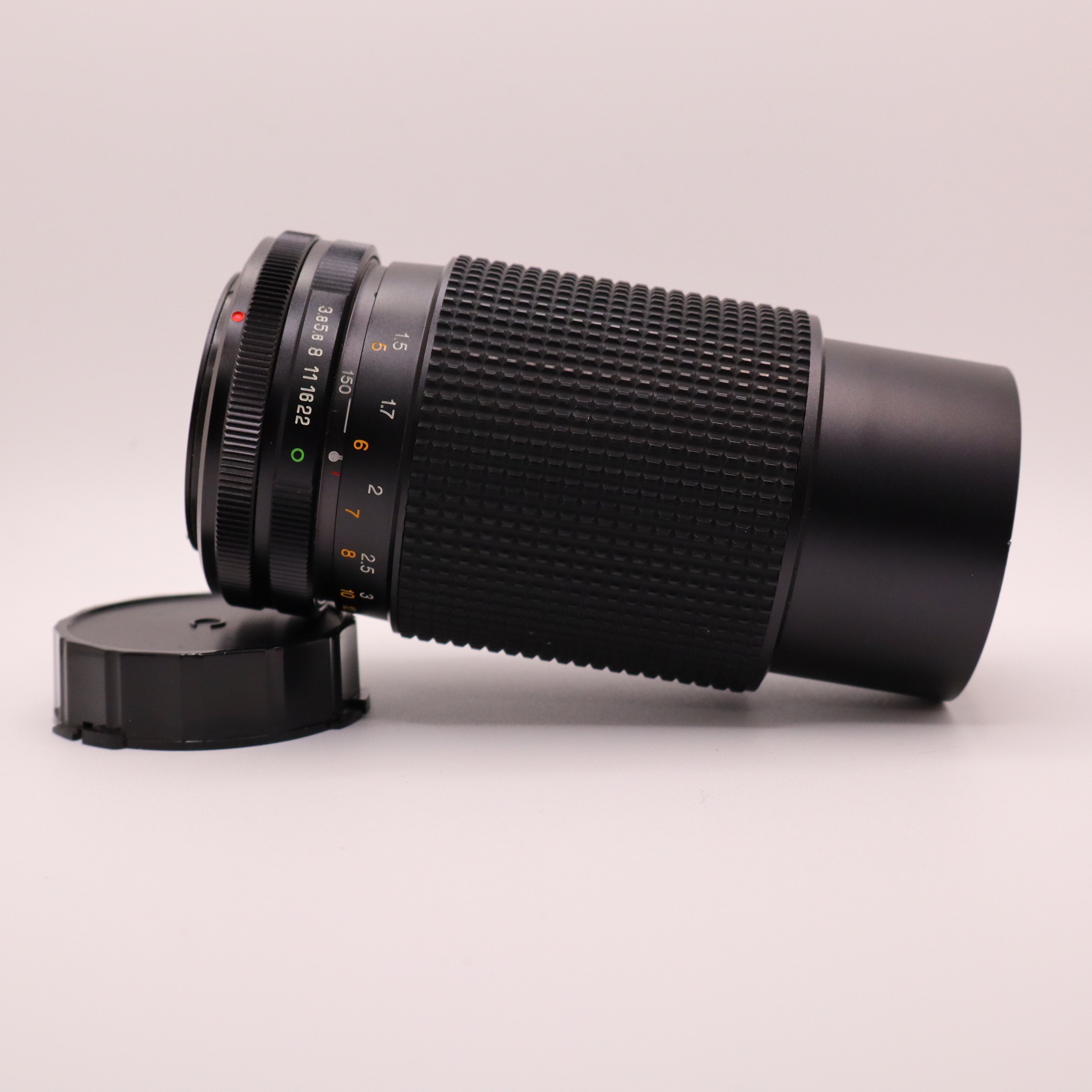 Camera lens with a cap on a light gray background