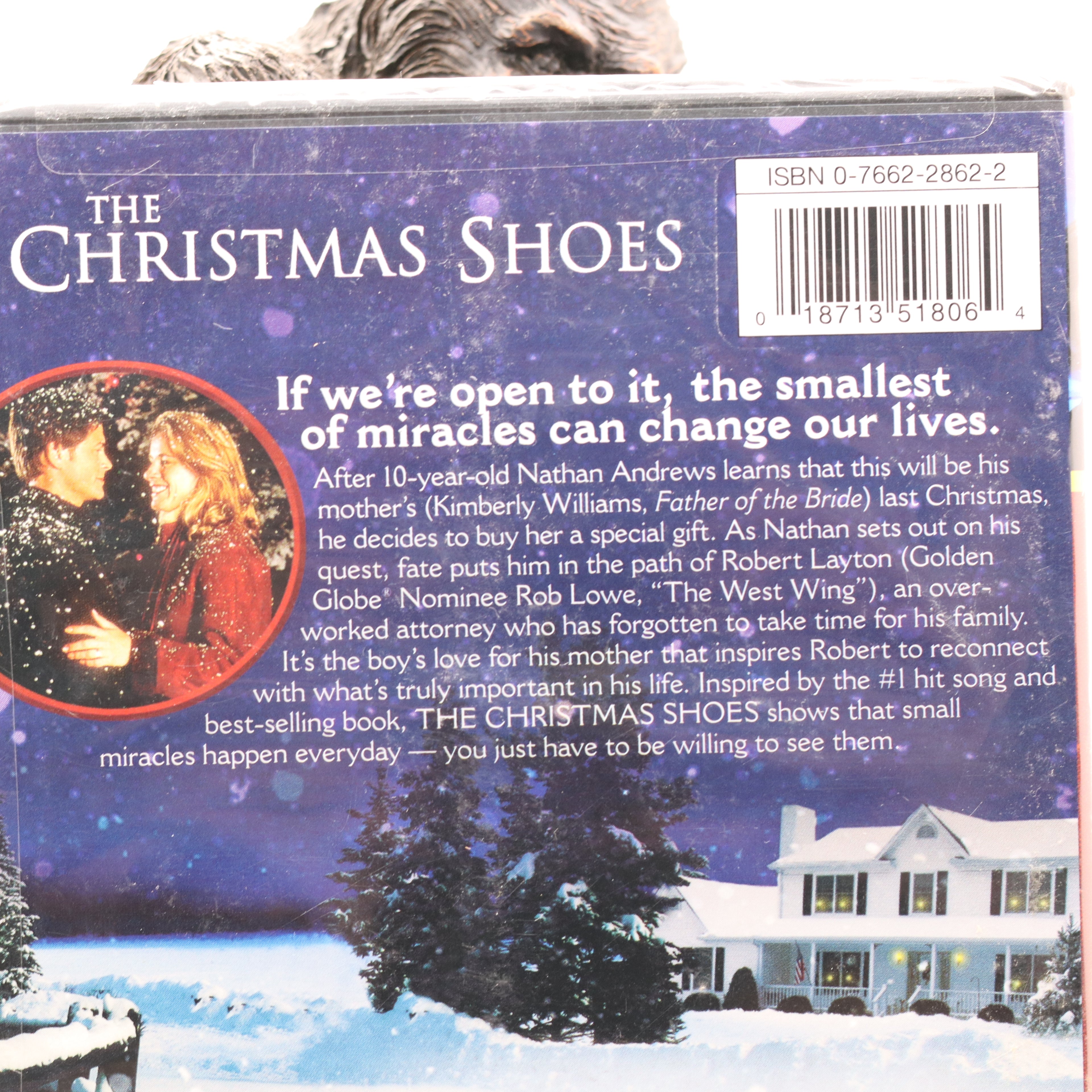 Back cover of 'The Christmas Shoes' book with a snowy scene and couple, featuring a barcode.