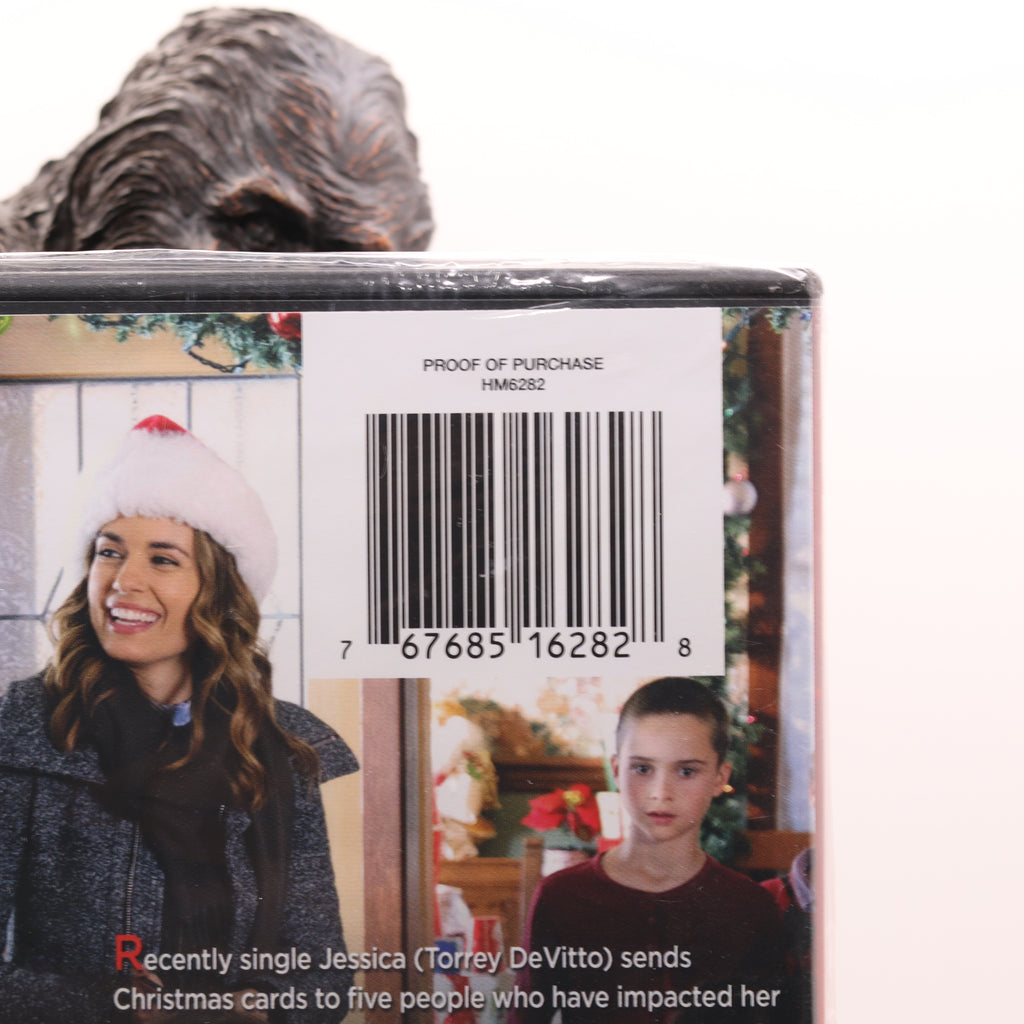 Back of a DVD case with a barcode and images of people, including a woman in a white hat and a boy.