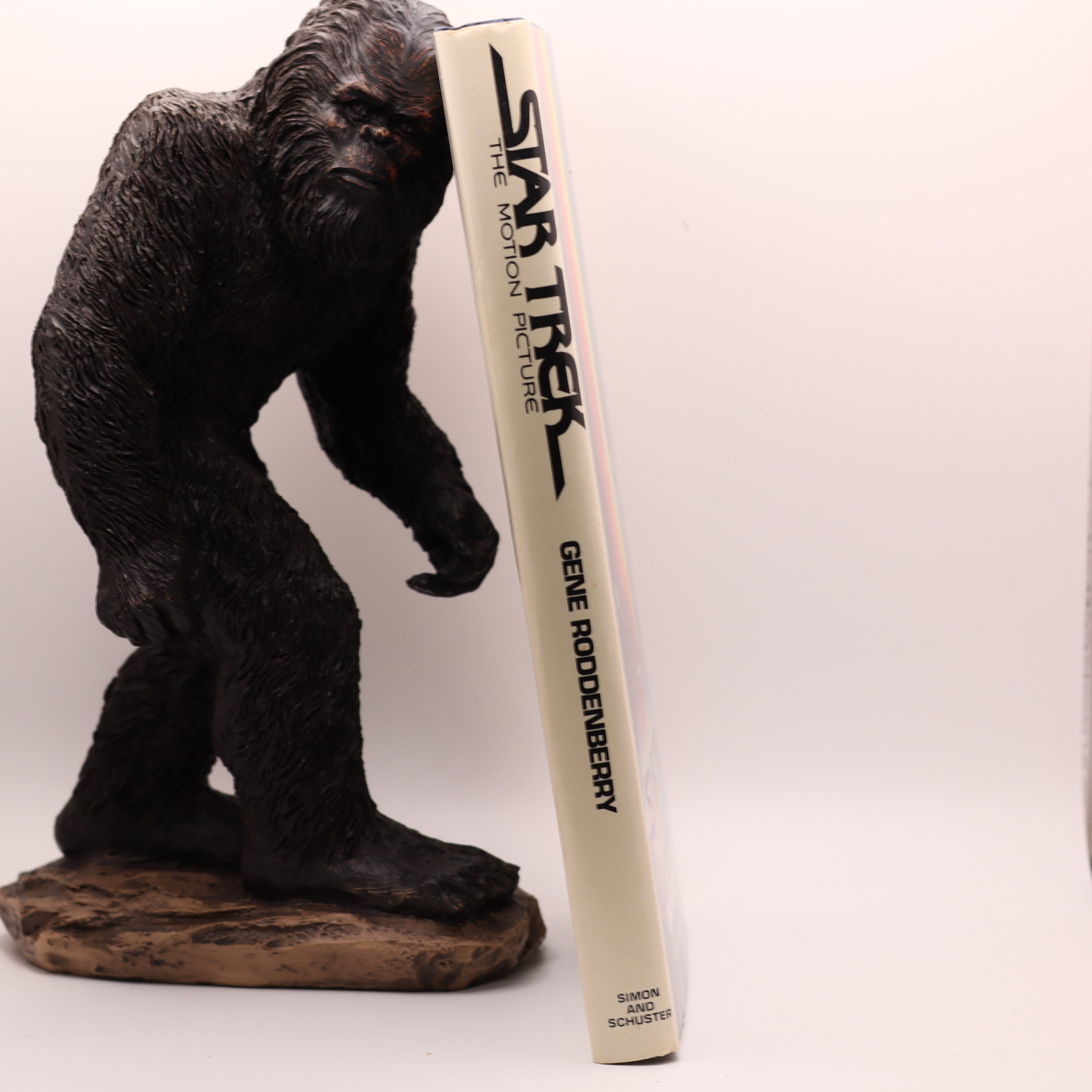 Gorilla figurine holding a 'Star Trek' book on a white background