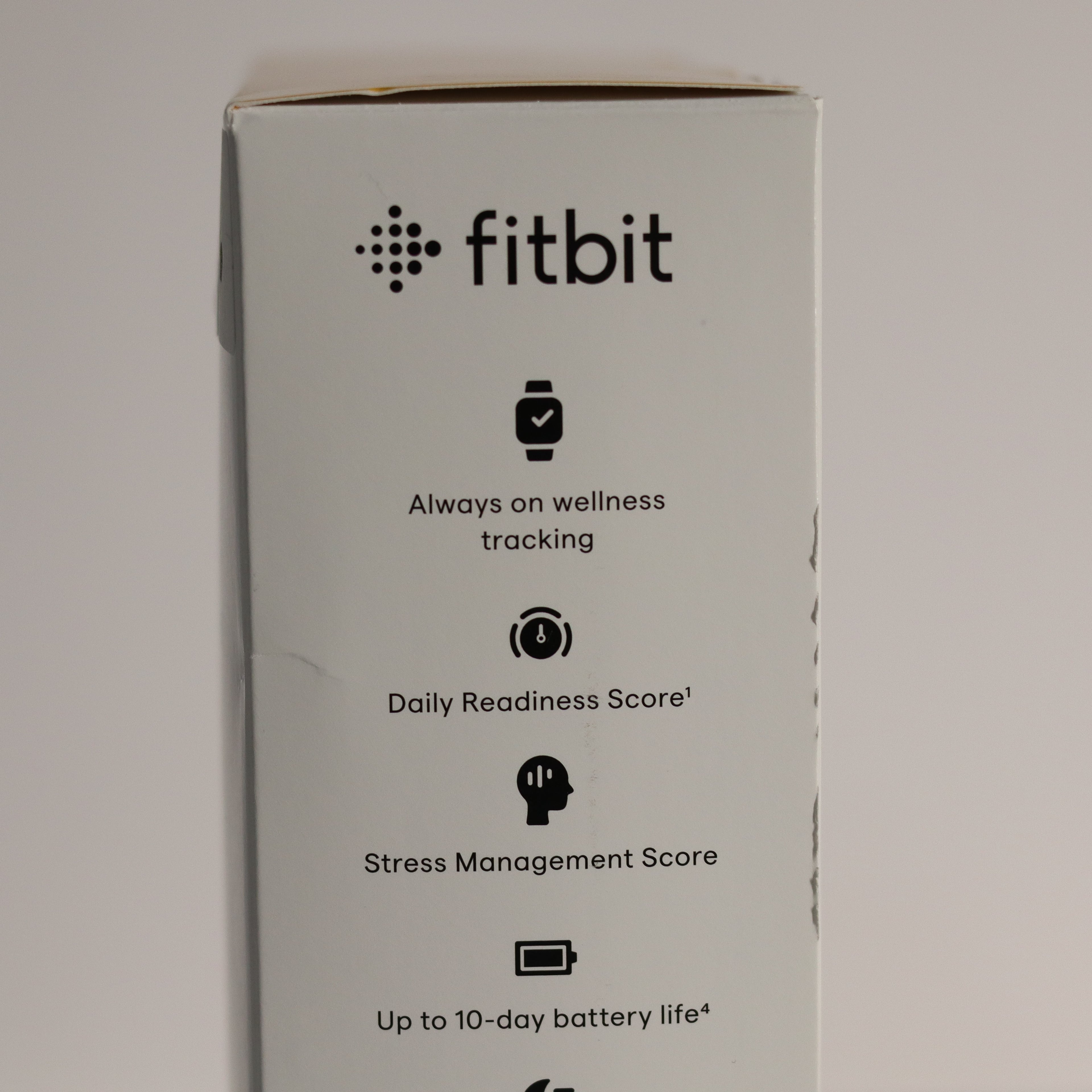 Fitbit product box with features listed on a gray background
