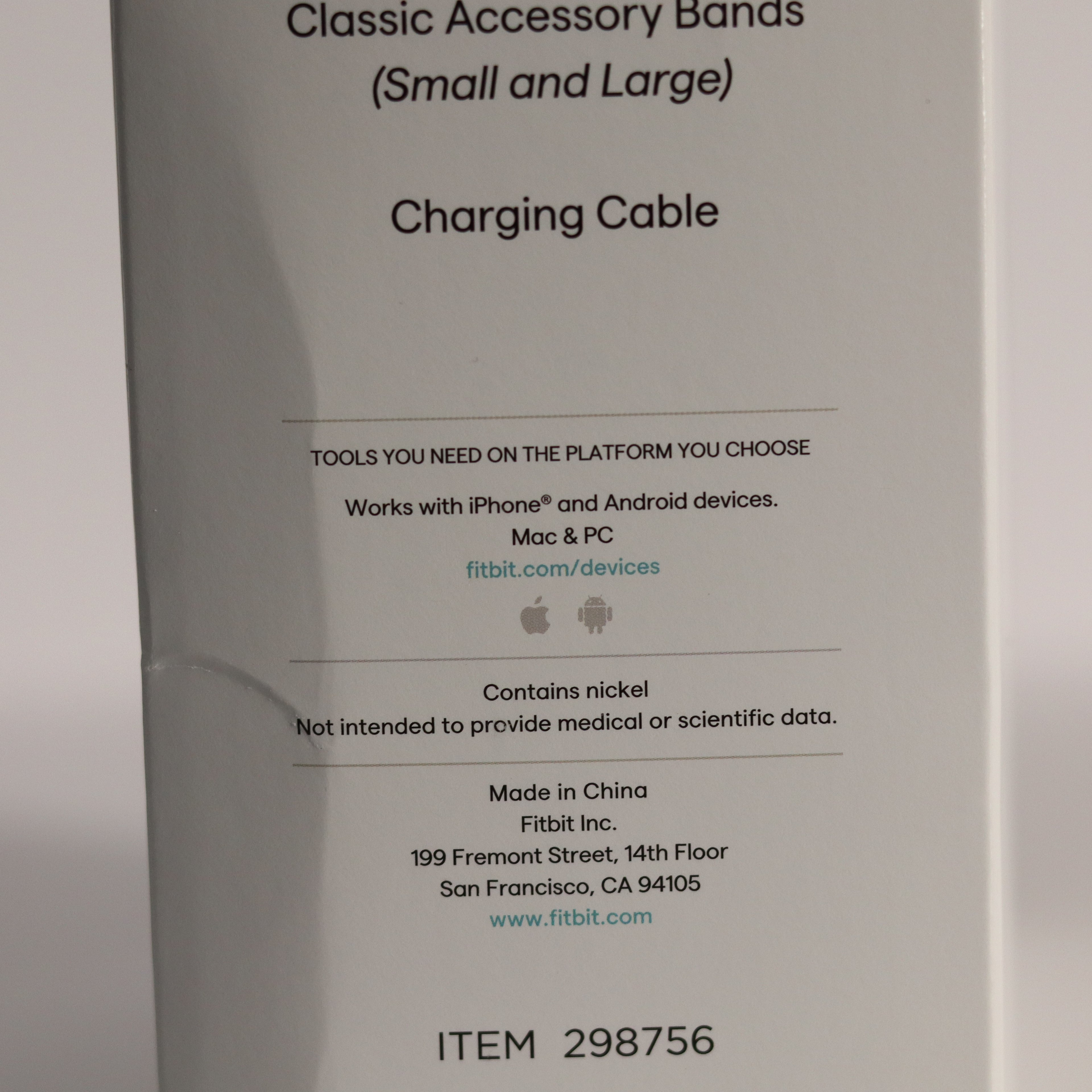 Fitbit accessory packaging with text about charging cable and product details.