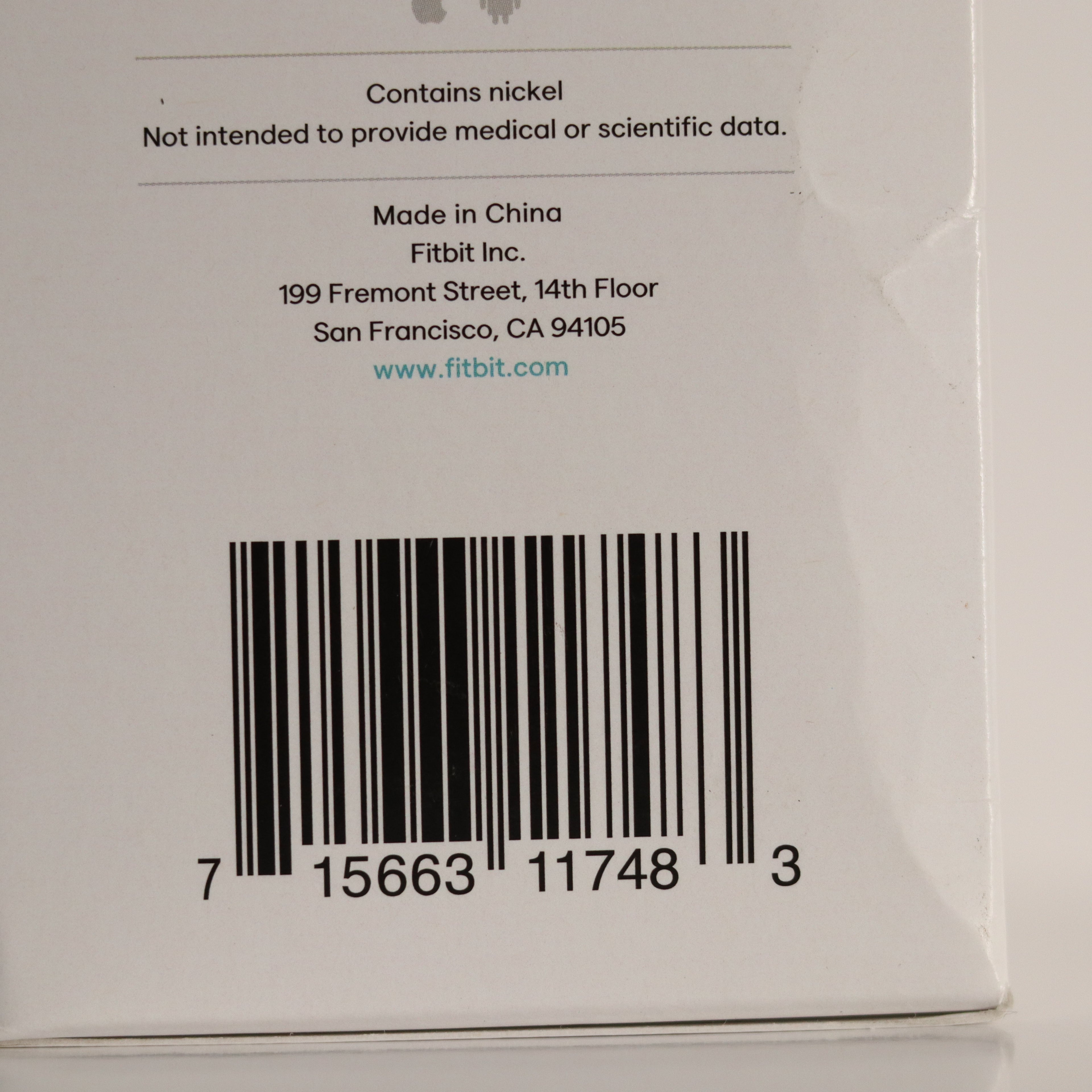 Back of a Fitbit product packaging with bar code and text