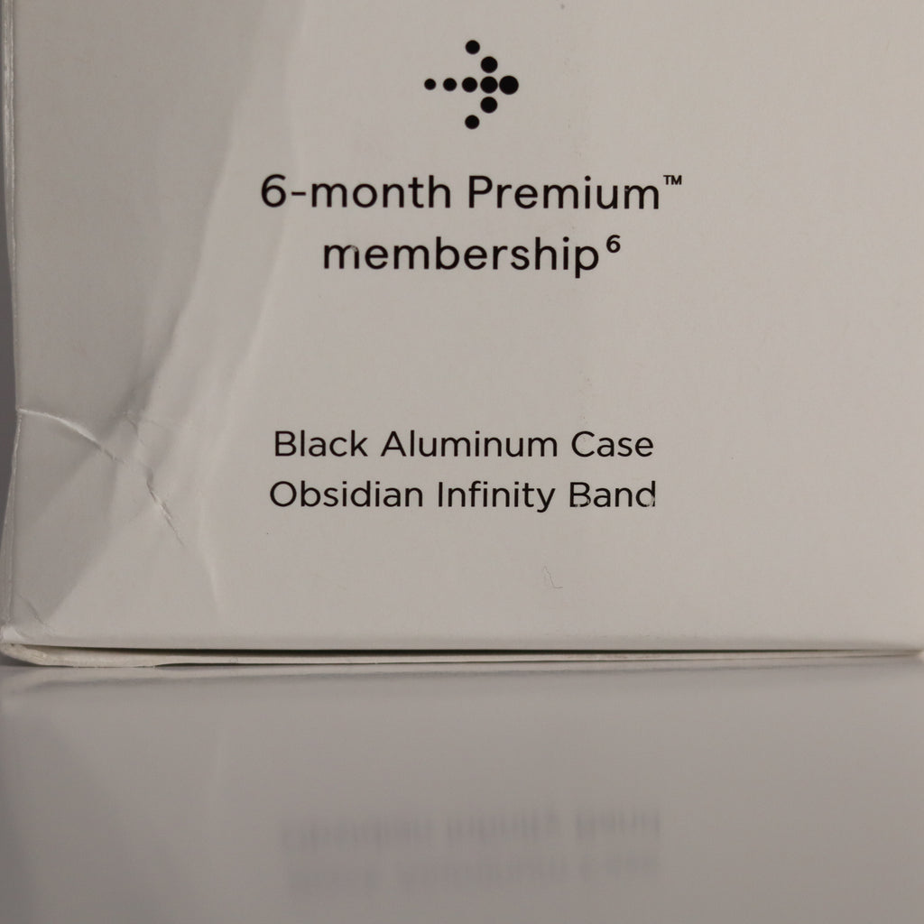 Product packaging with text about a 6-month premium membership, black aluminum case, and obsidian infinity band.