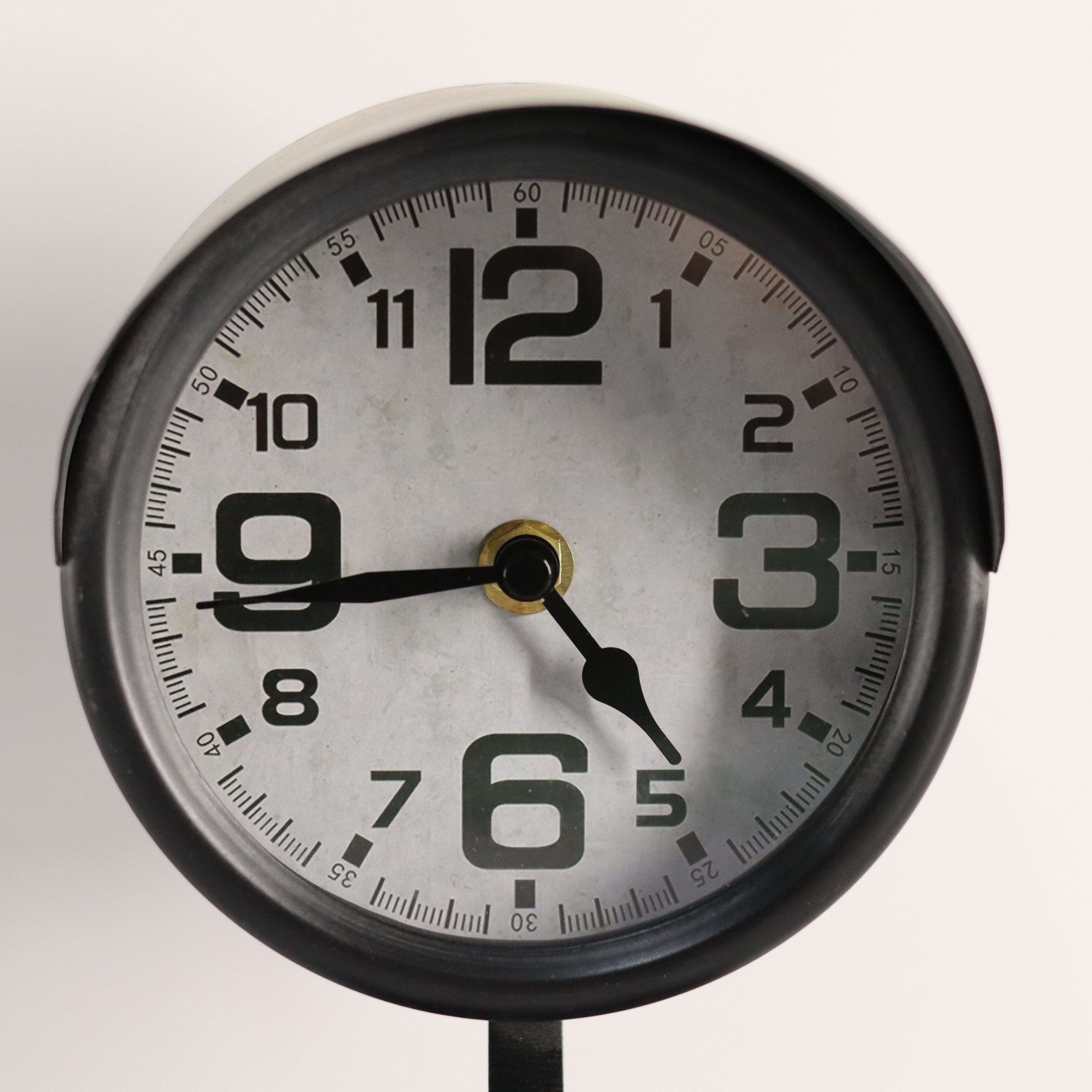 Round clock with black and white design on a plain background