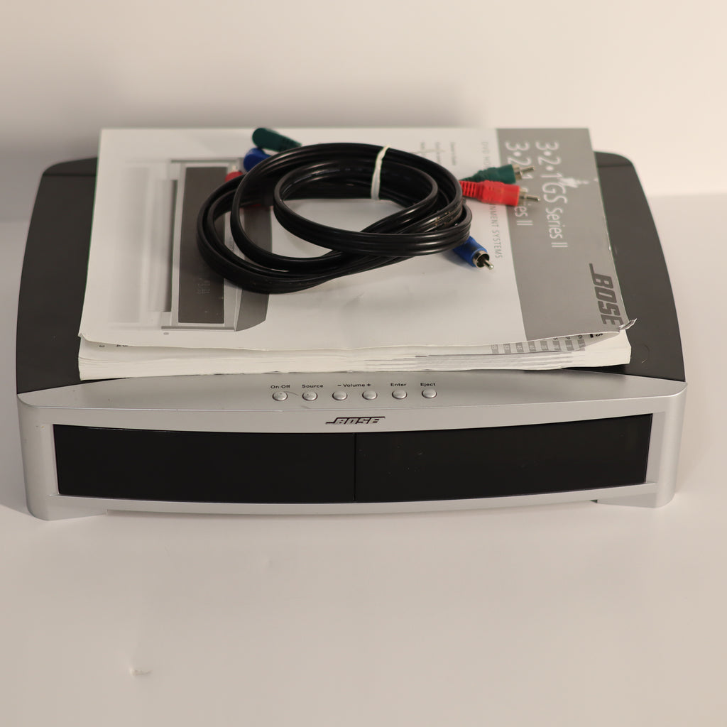 Bose sound system with cables and manual on a white surface