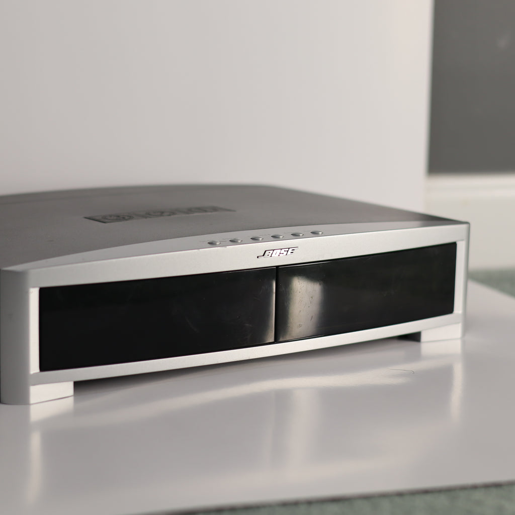 Silver electronic device on a reflective surface with a blurred background