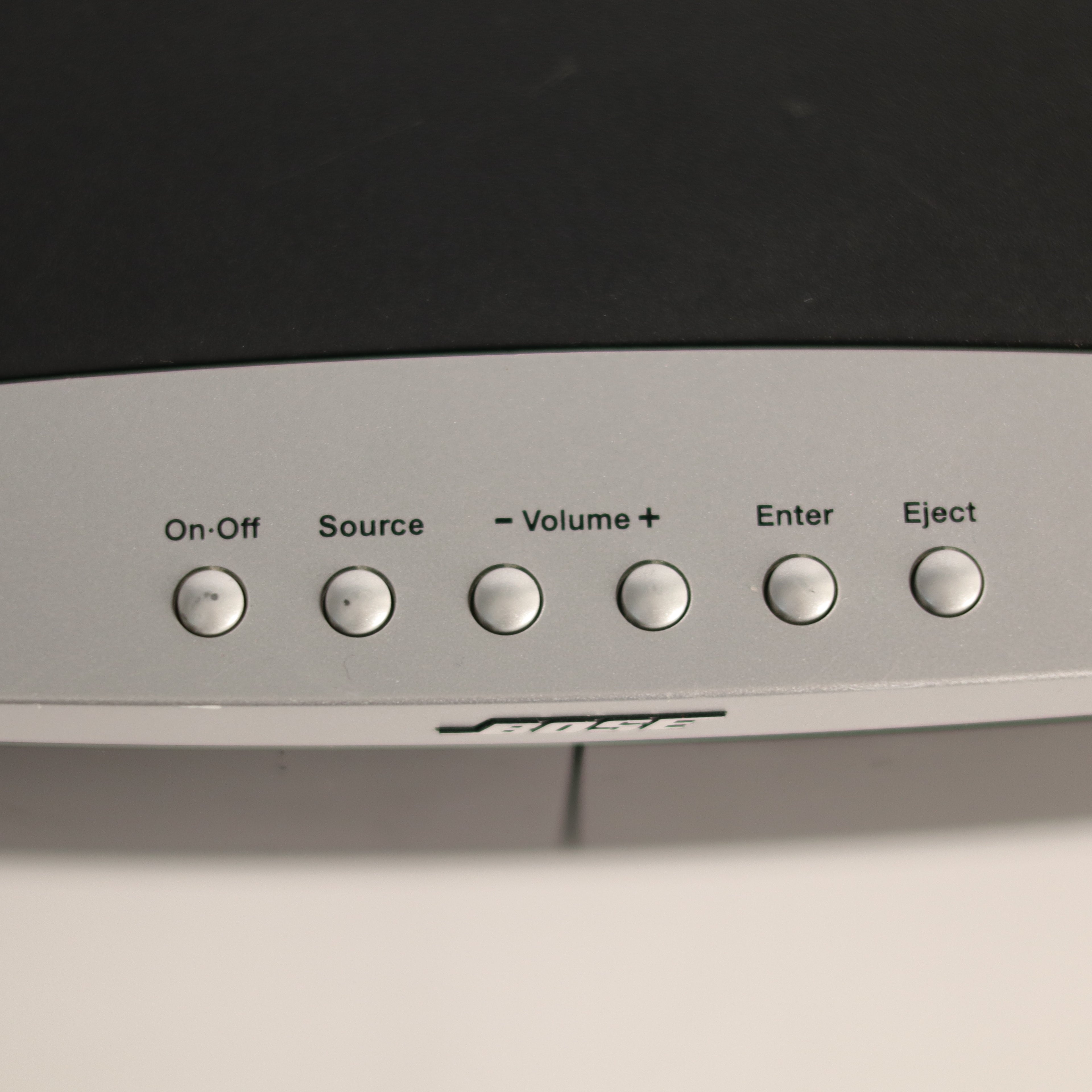 Control panel with buttons labeled On-Off, Source, Volume+, Enter, and Eject on a black background.