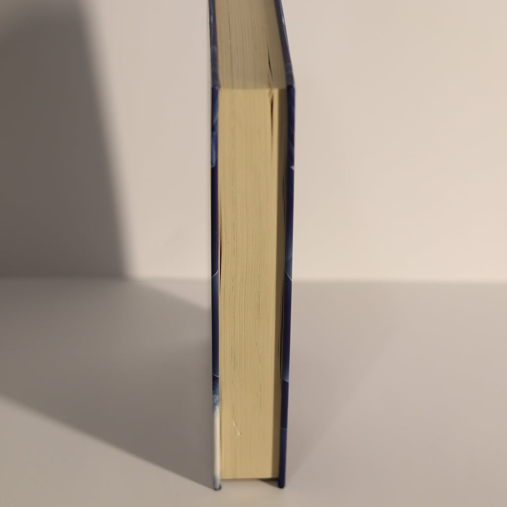 Close-up of a book with a blue spine on a beige background