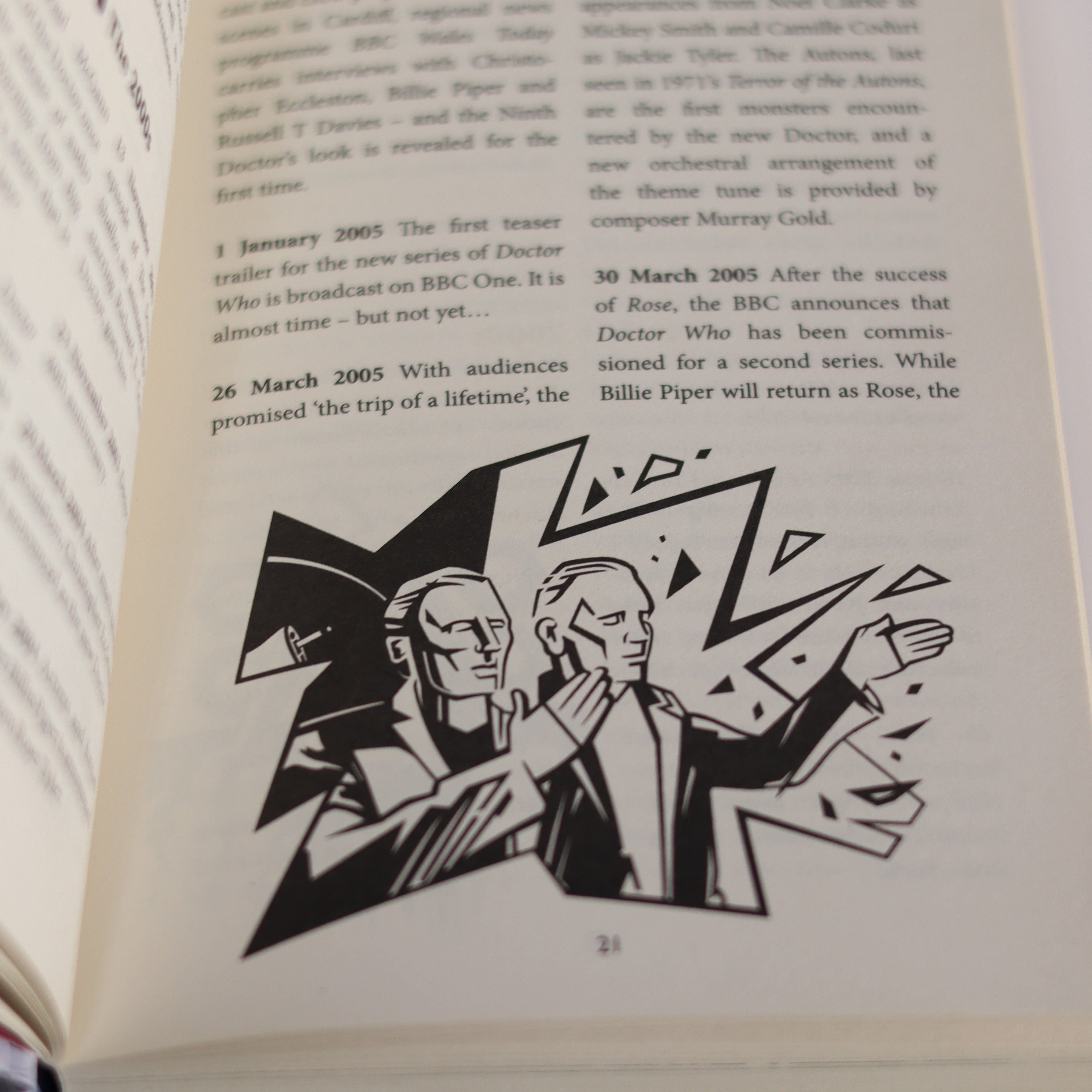 Open book with black and white illustration of two figures on a white background