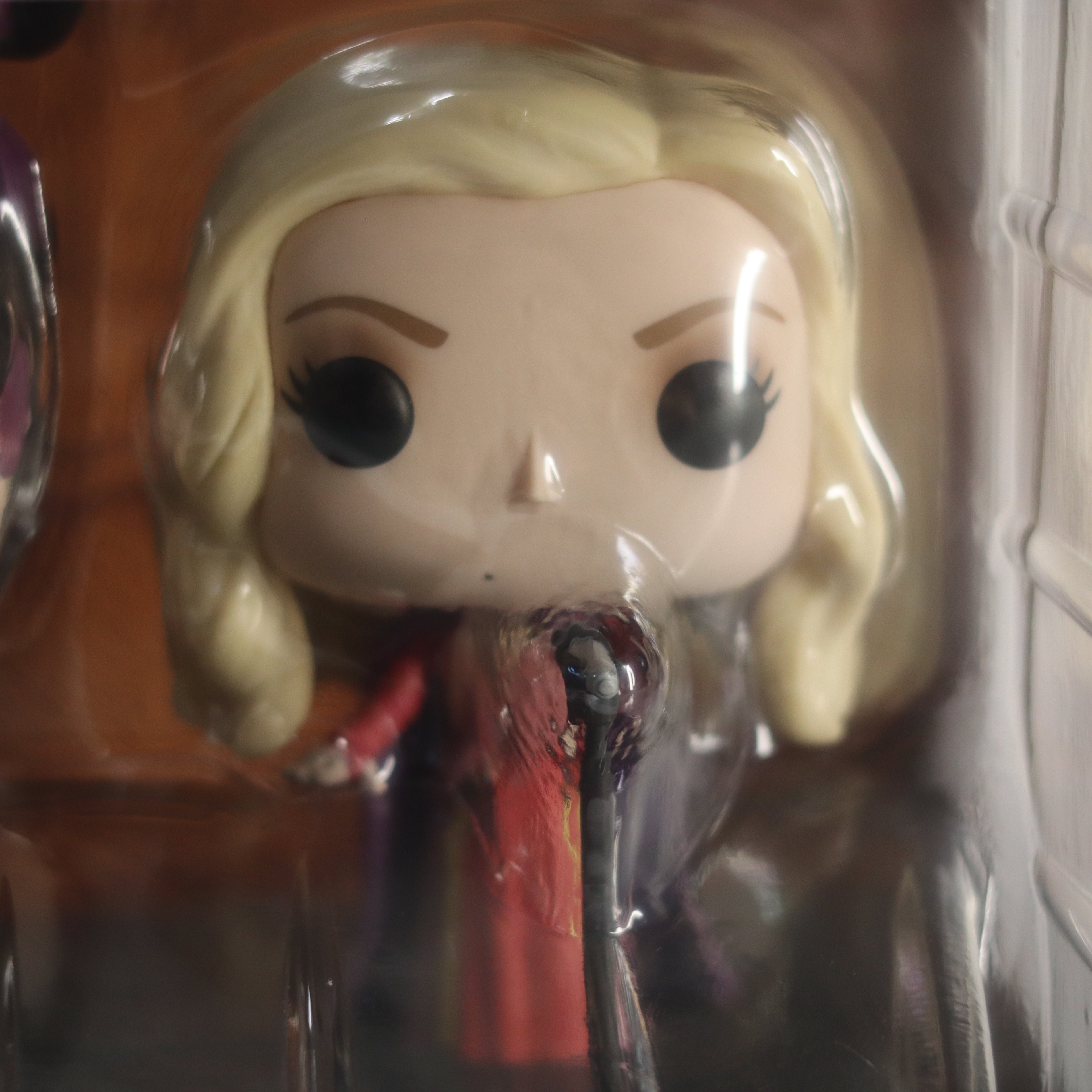 Pop vinyl figure with blonde hair and red outfit in clear packaging.