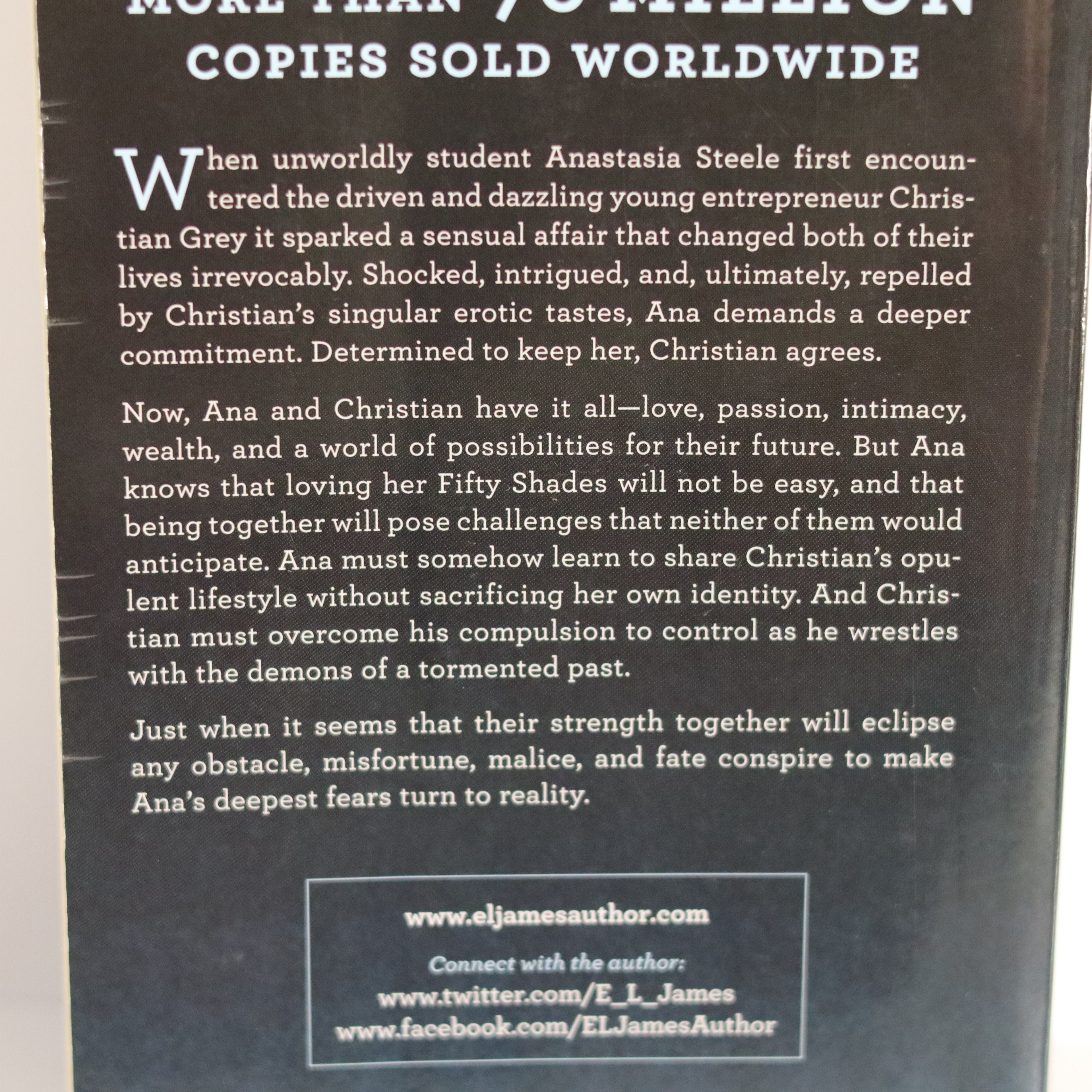 Book back cover with text about a sensual affair between two characters, with a dark background.