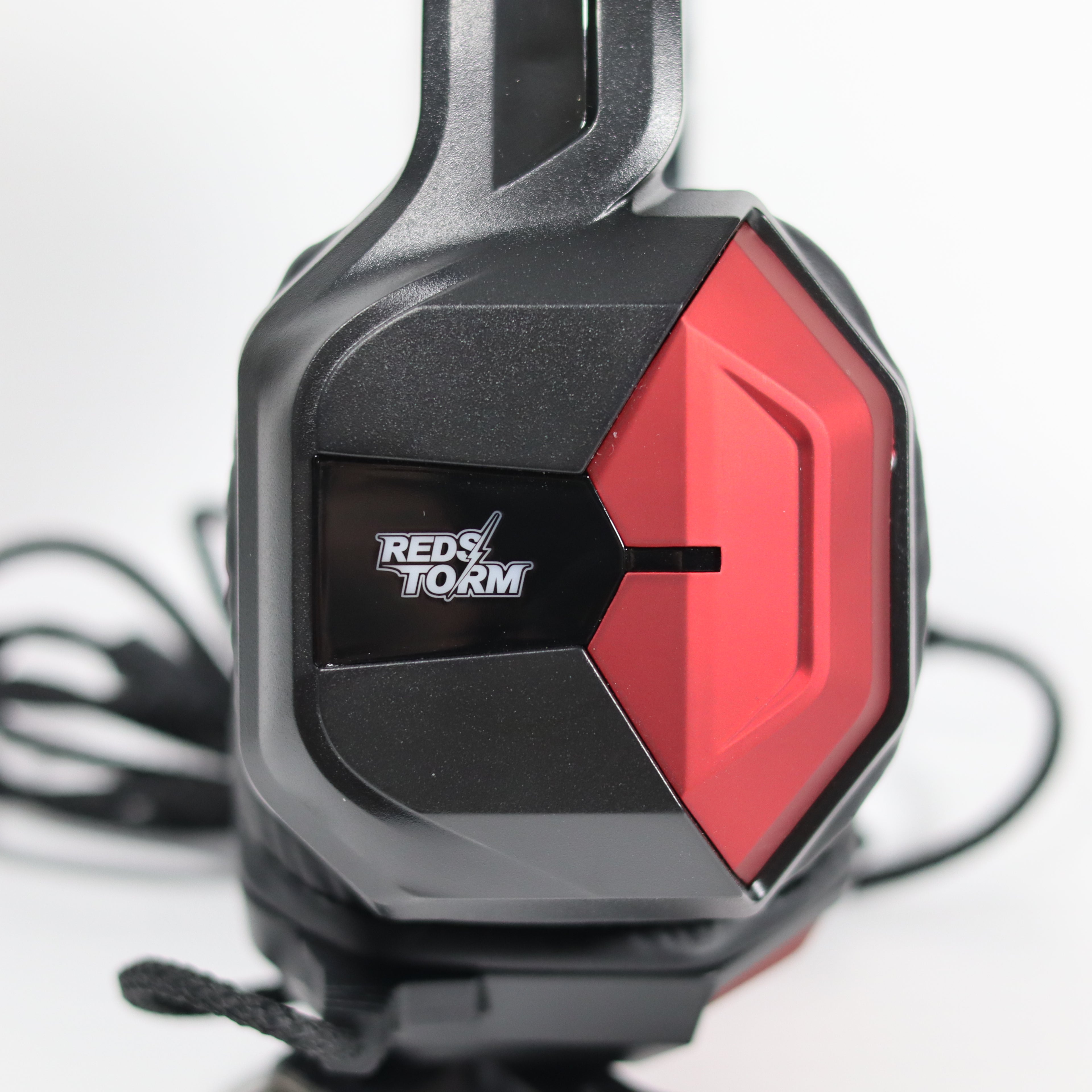 Close-up of a gaming headset with red and black design, featuring the Red Storm logo.