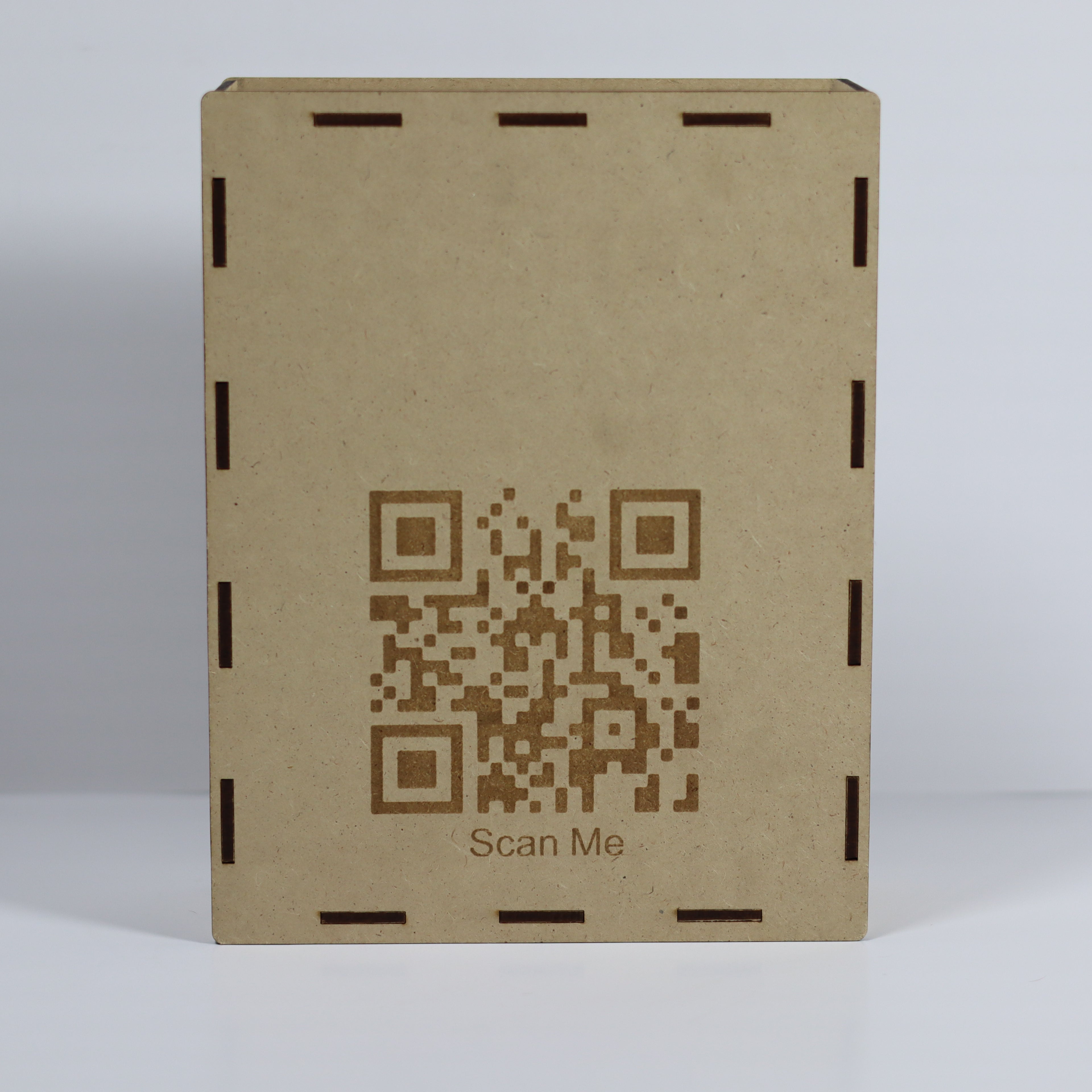 Brown cardboard box with a QR code and 'Scan Me' text on a light gray background