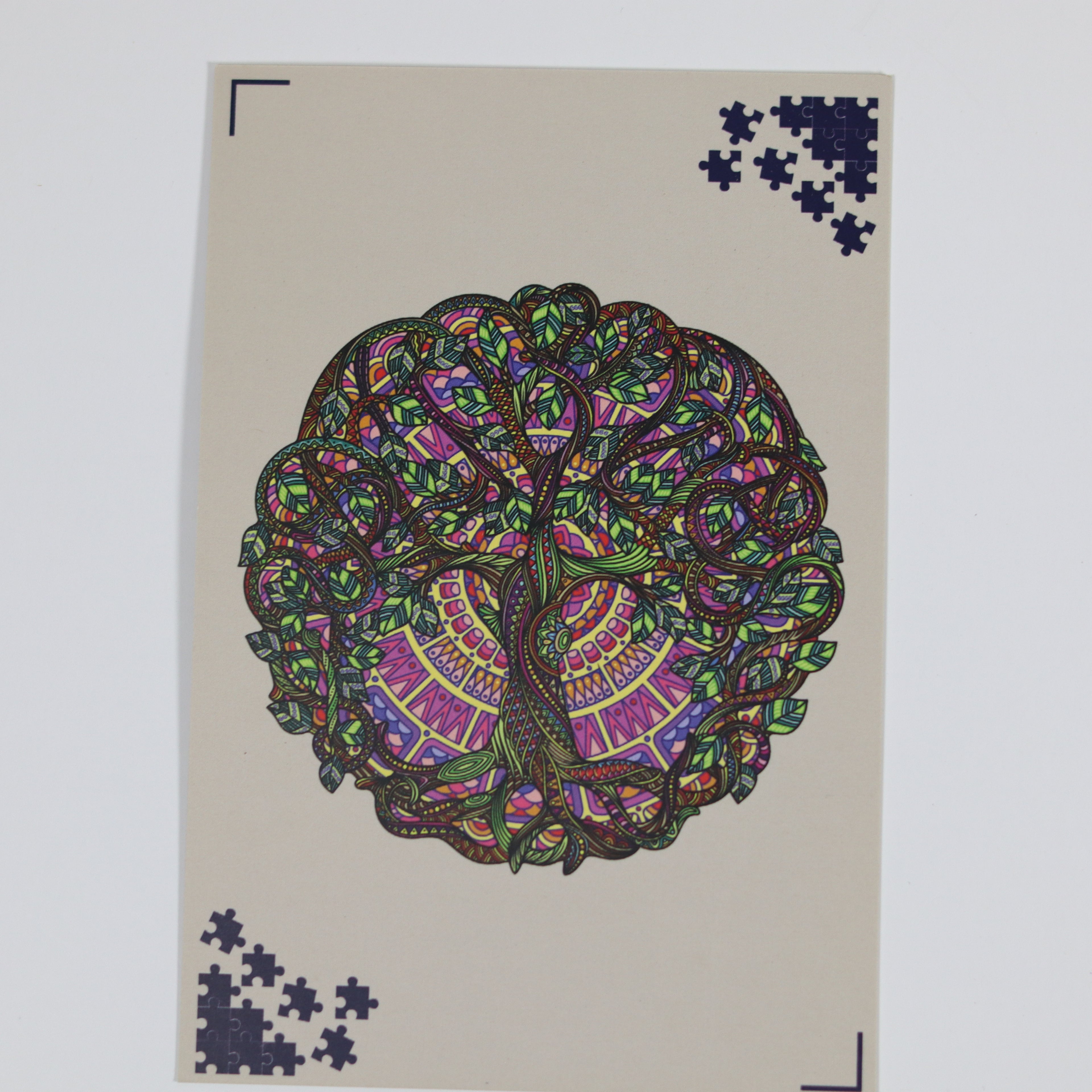 Colorful tree design on a beige card with scattered puzzle pieces.