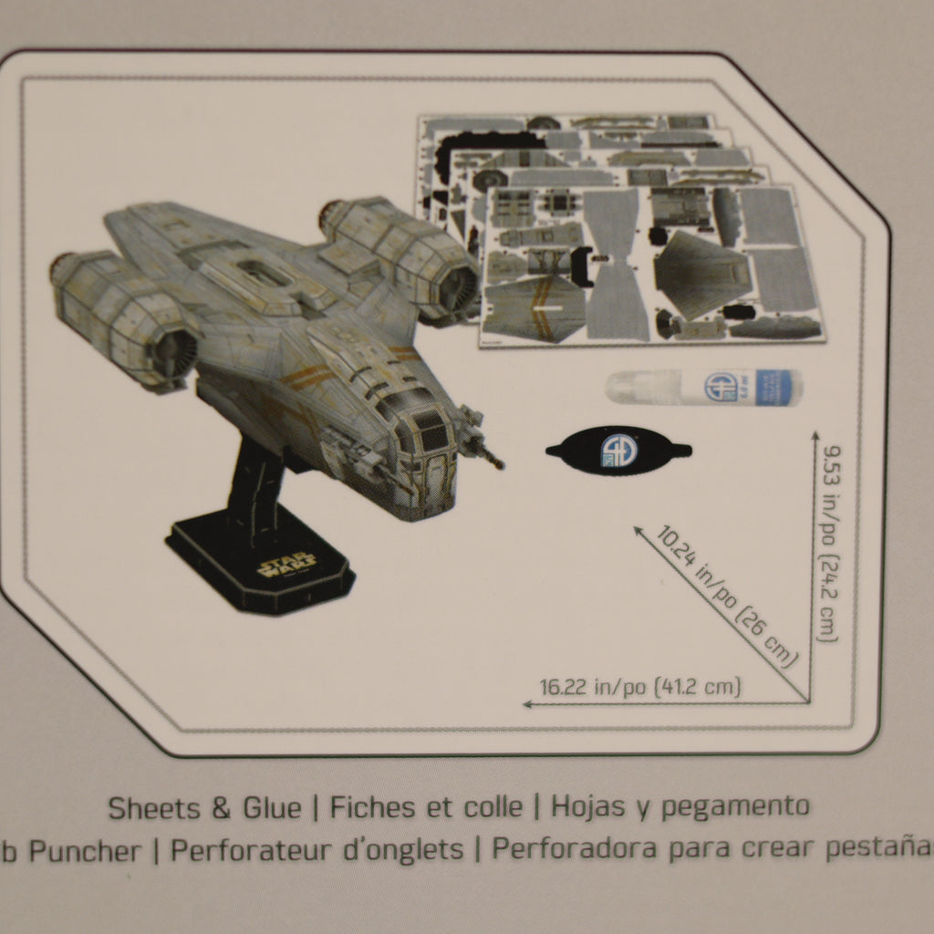 Model spaceship kit with decals and glue on a cardboard backing