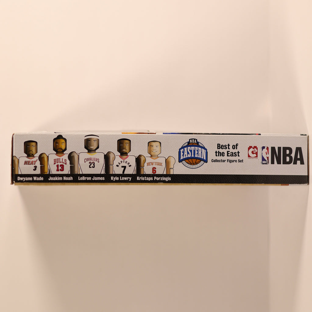 Box of NBA collectible figures on a beige background