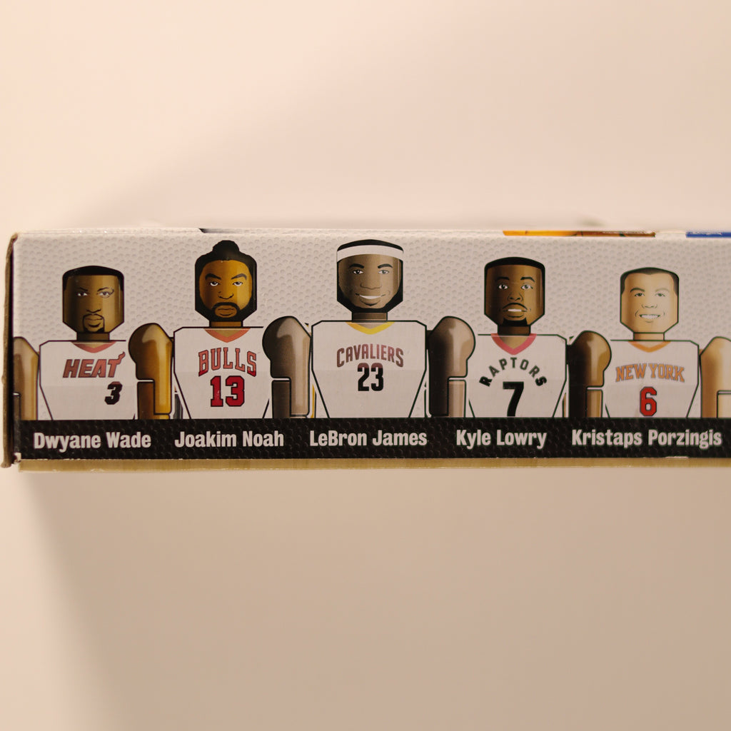 Box with cut-out figures of famous athletes on a beige background