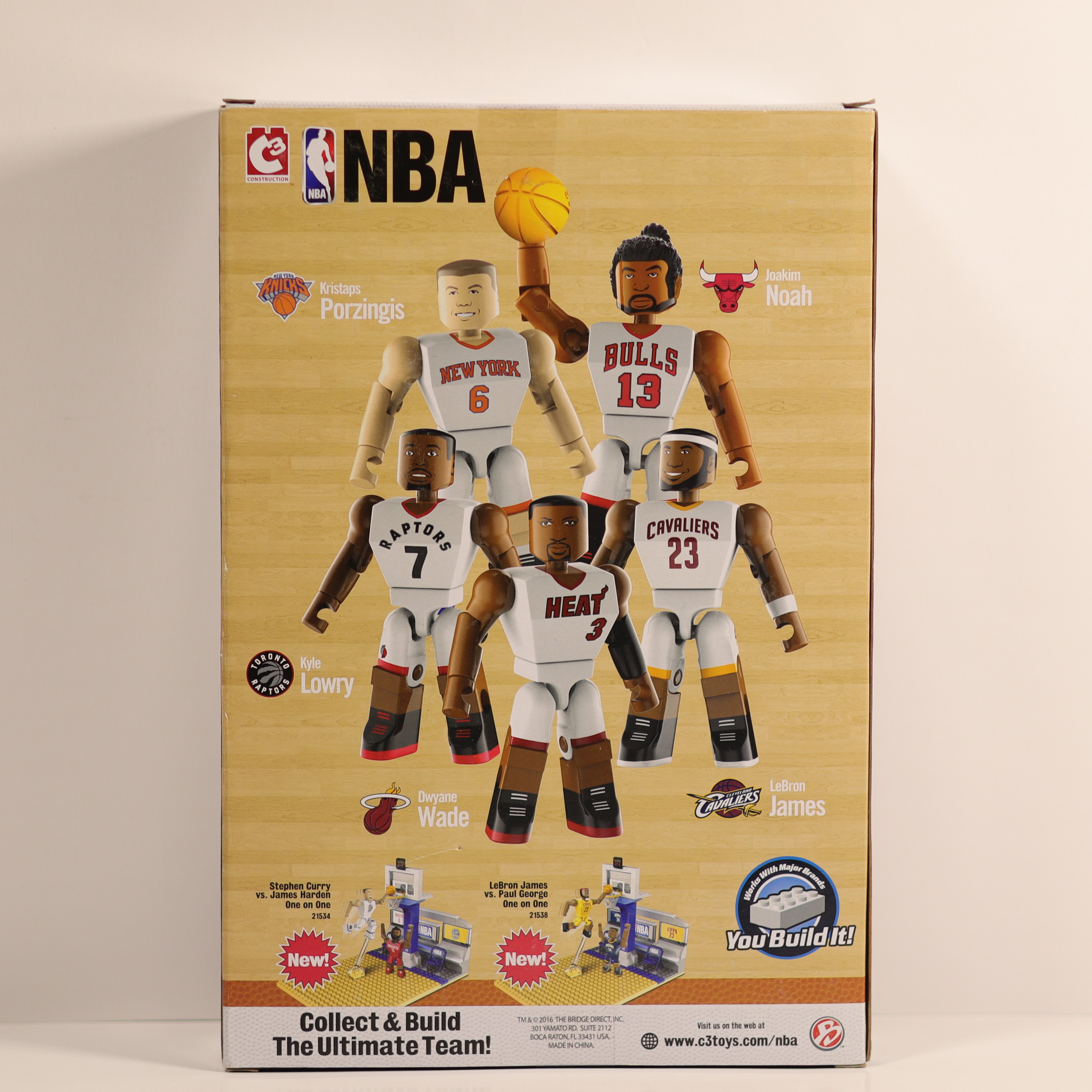 Box of NBA action figures with player illustrations on a beige background