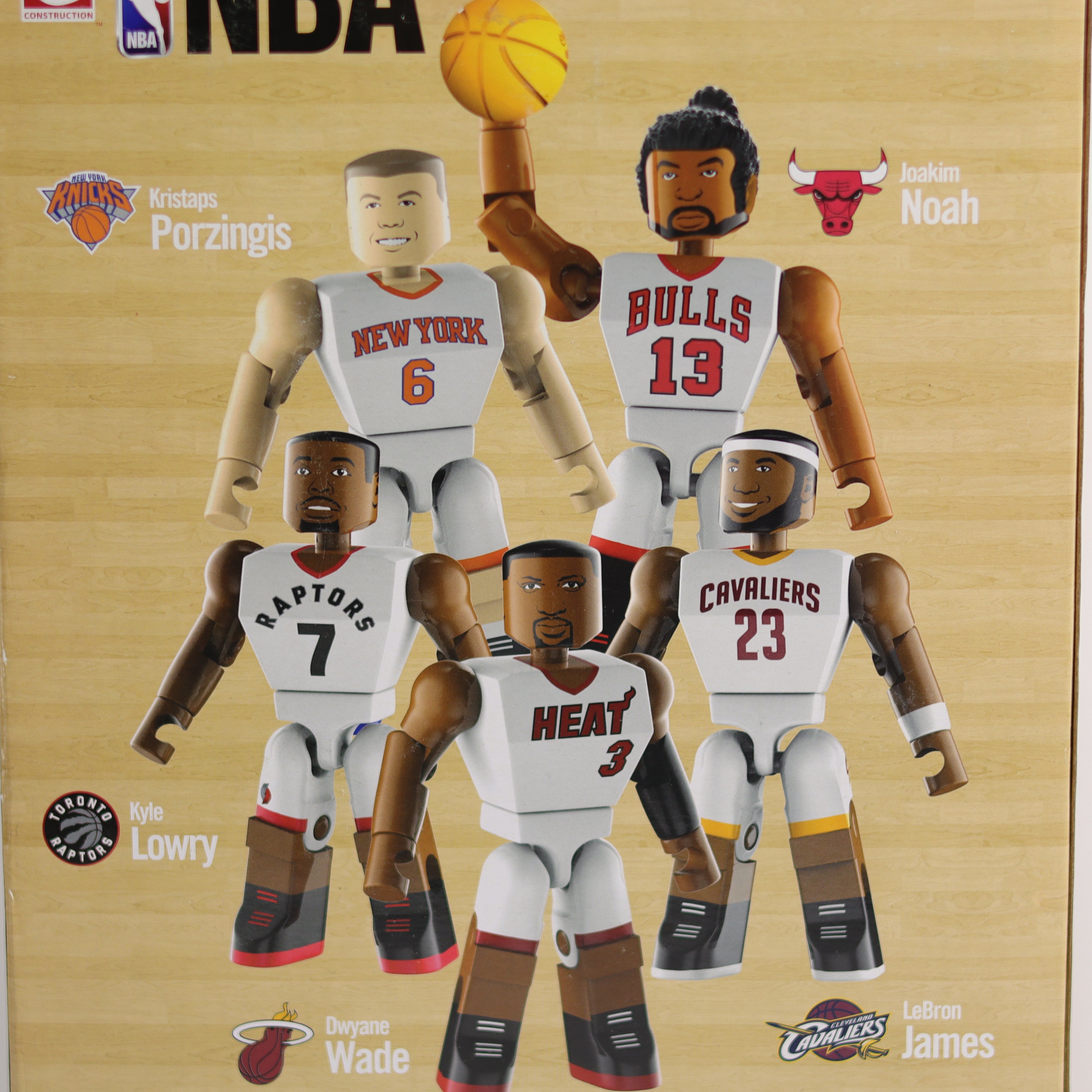 Box featuring action figures of NBA players with team logos on a wooden background