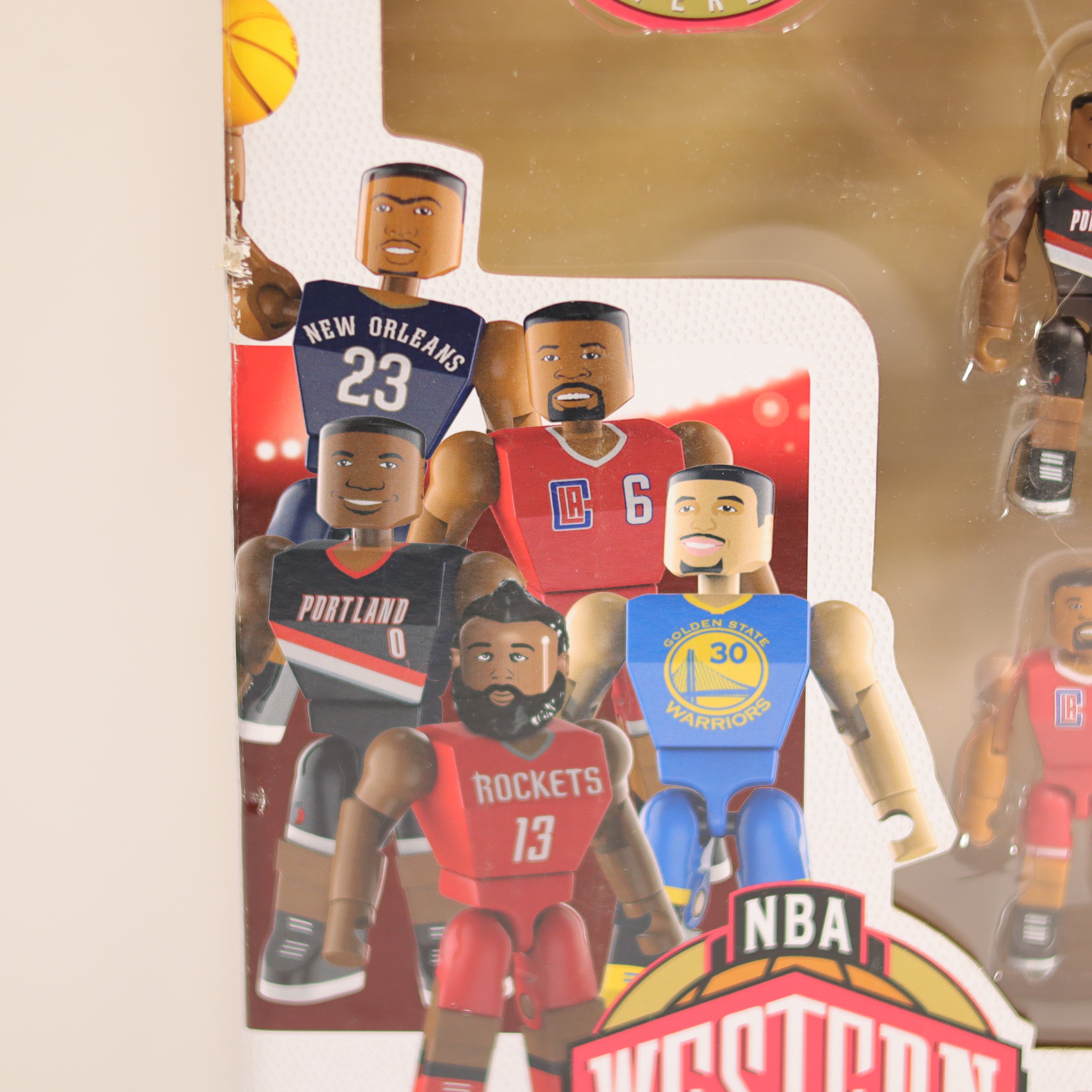 Collection of basketball player figurines with NBA branding on a beige background