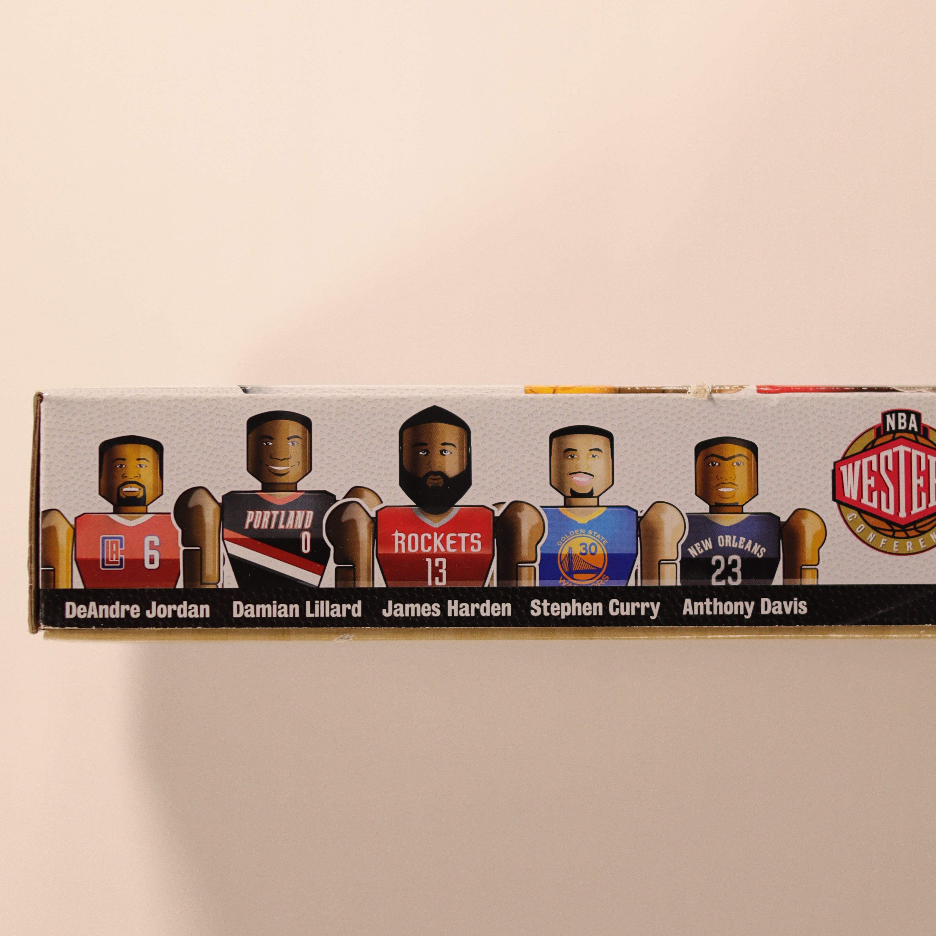 Box with images of basketball players and team logos on a beige background