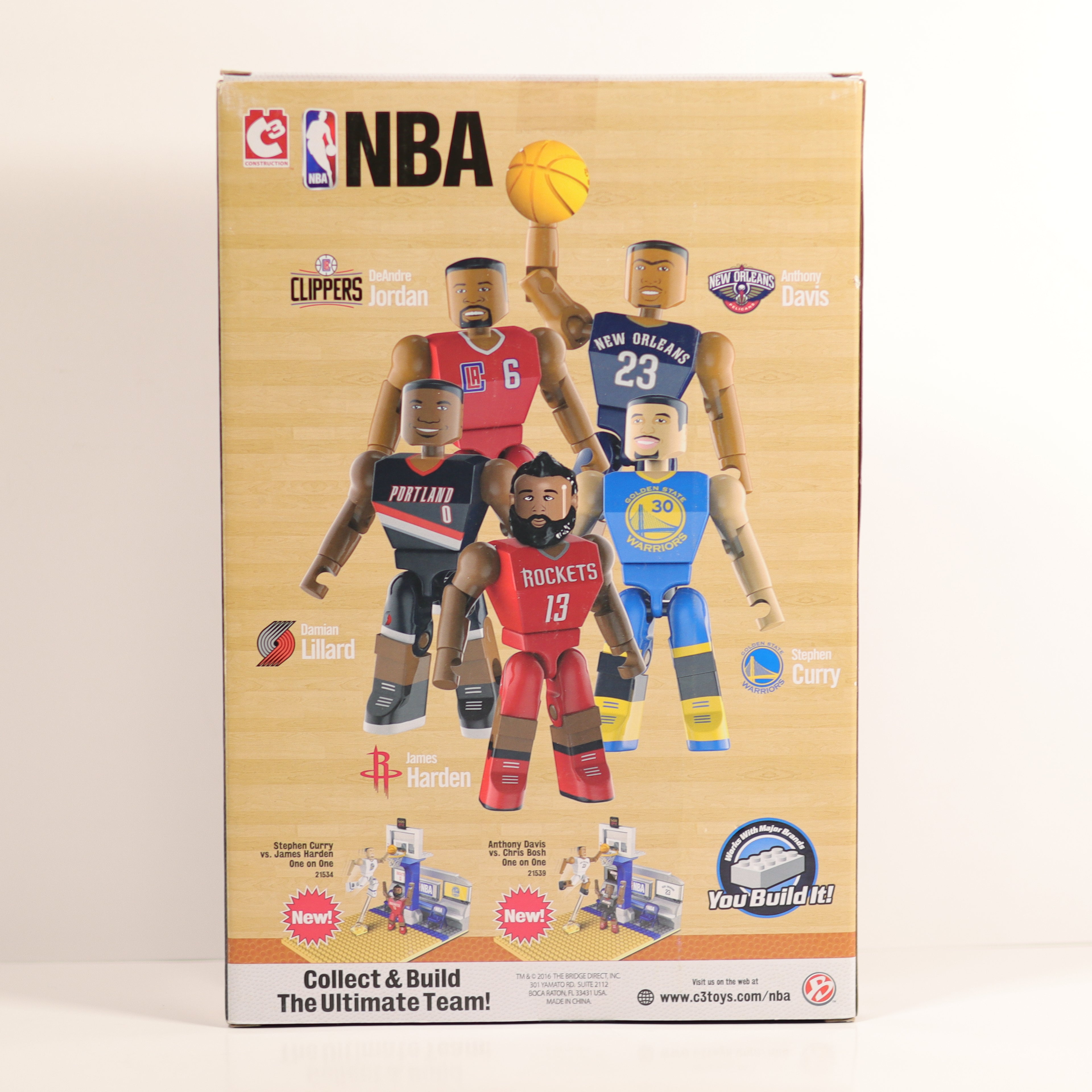 Box of NBA action figures with player uniforms and branding.