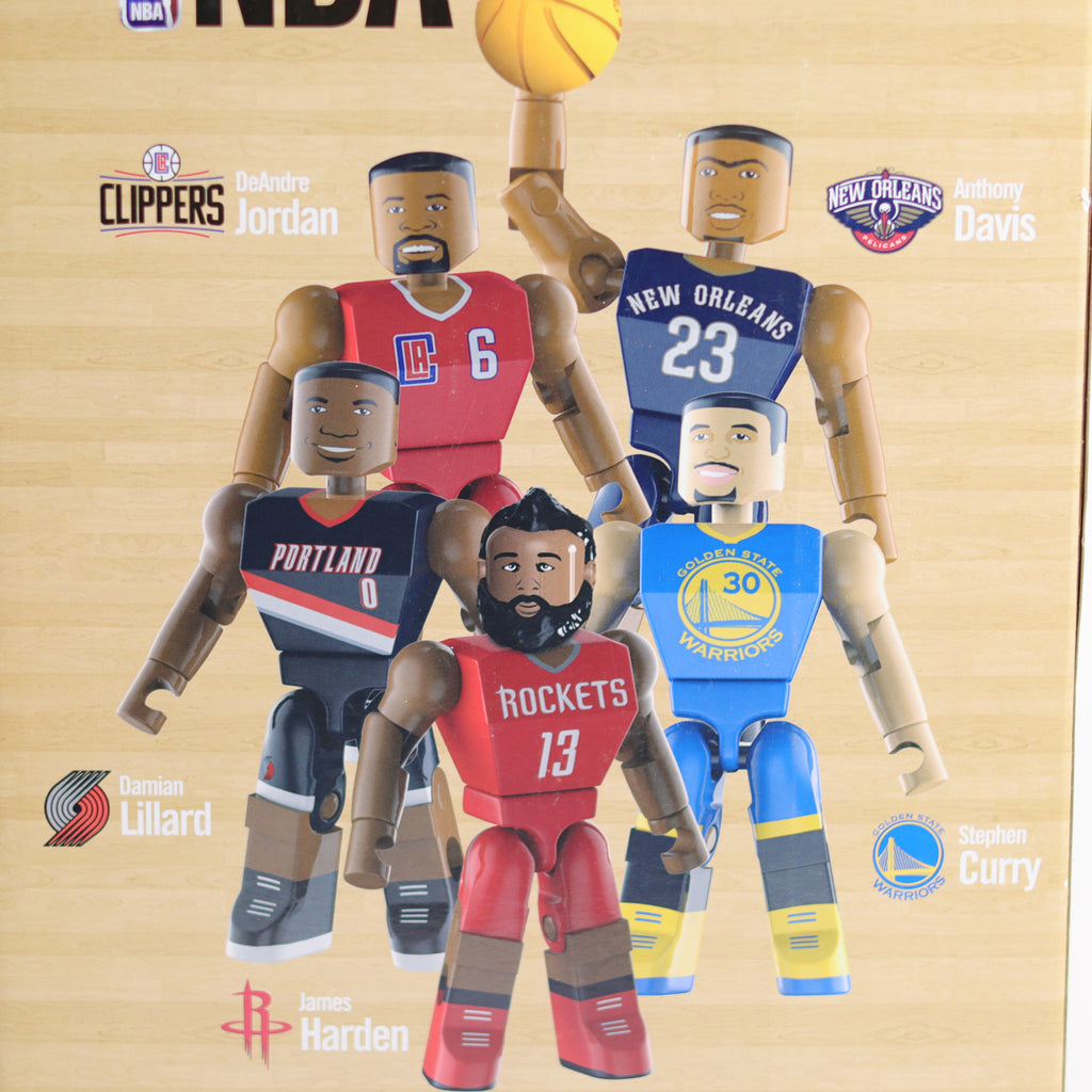 Figurines of basketball players from different teams on a wooden background