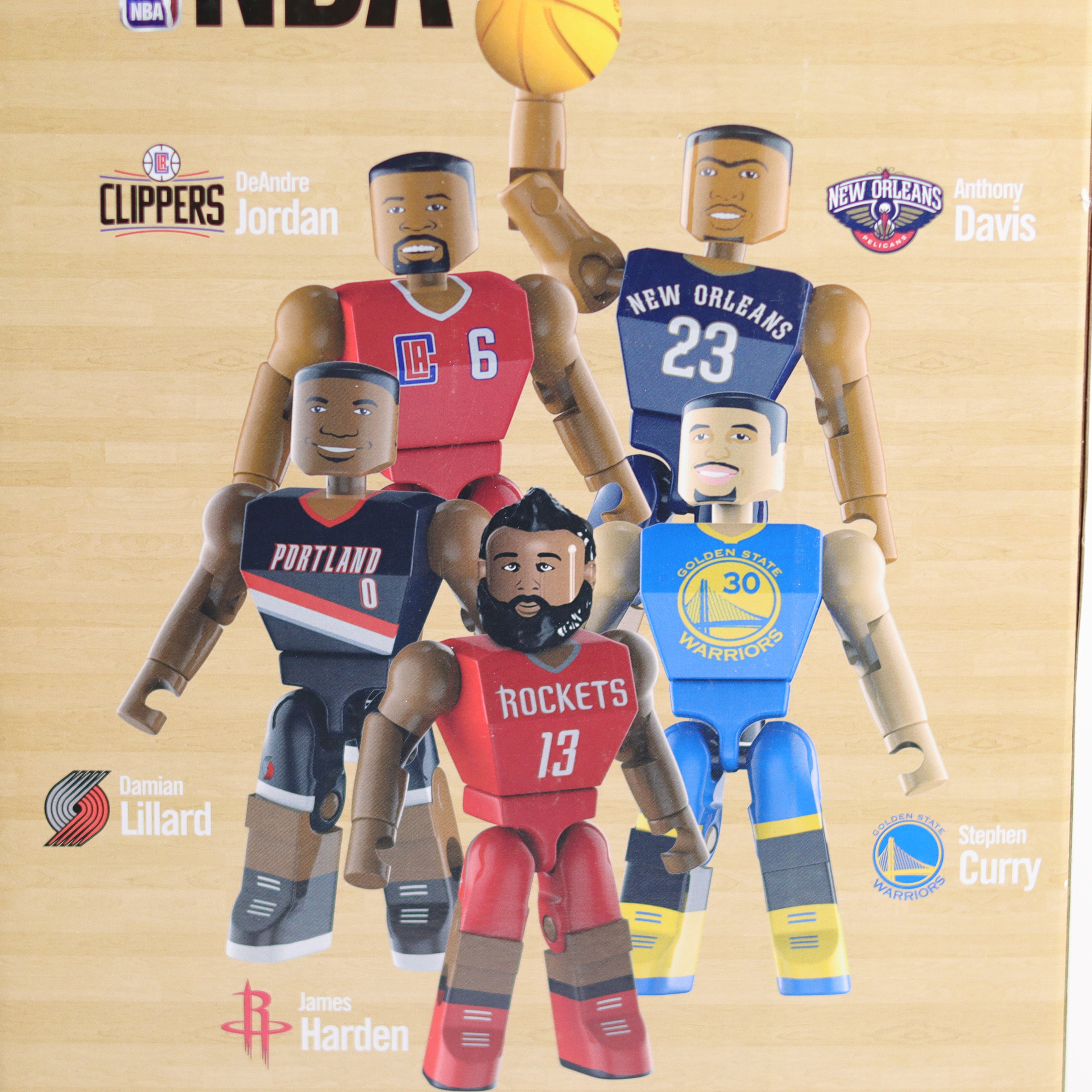 Figurines of basketball players from different teams on a wooden background