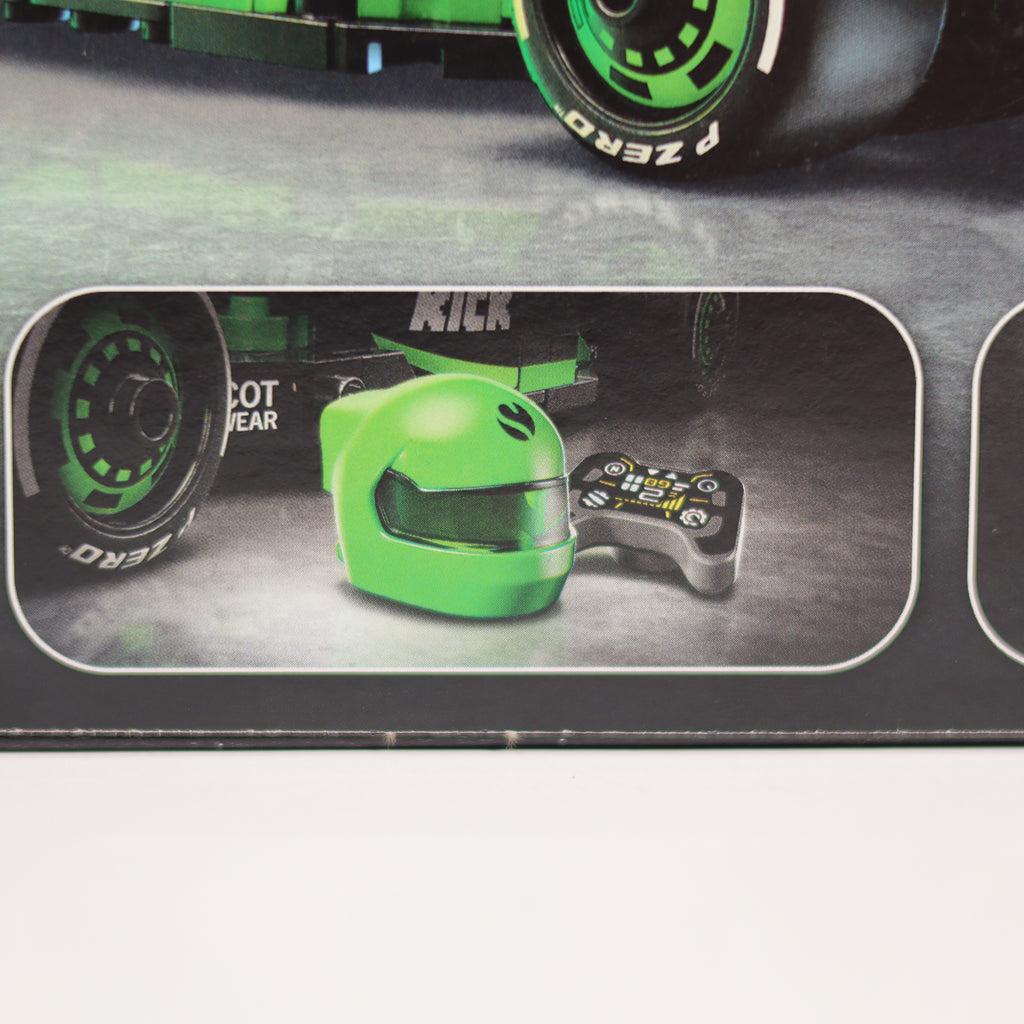 Close-up of a green helmet and black boot with 'KICK' branding, displayed on a metallic surface.