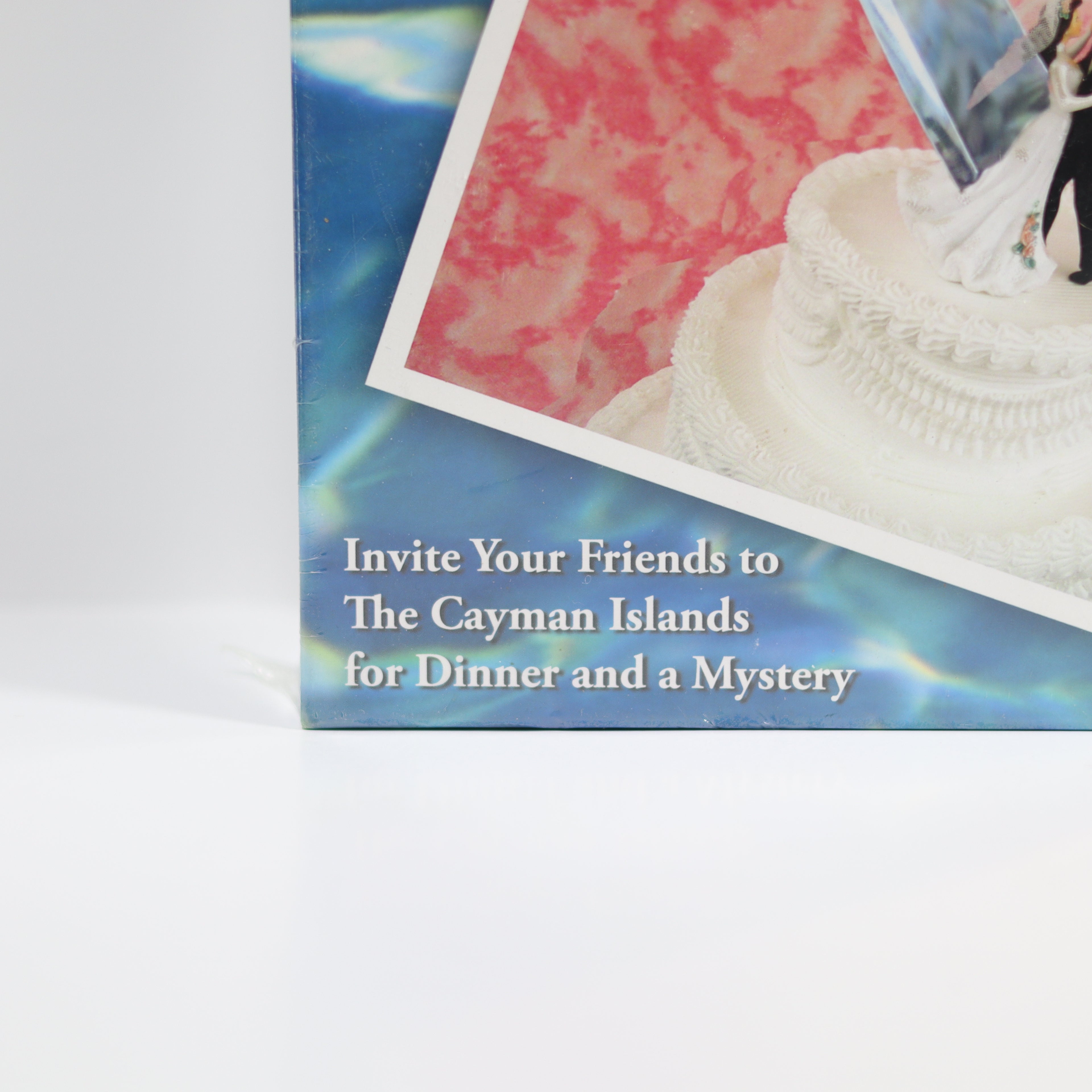 Advertisement for The Cayman Islands with a scenic background and text inviting friends to dinner and a mystery.