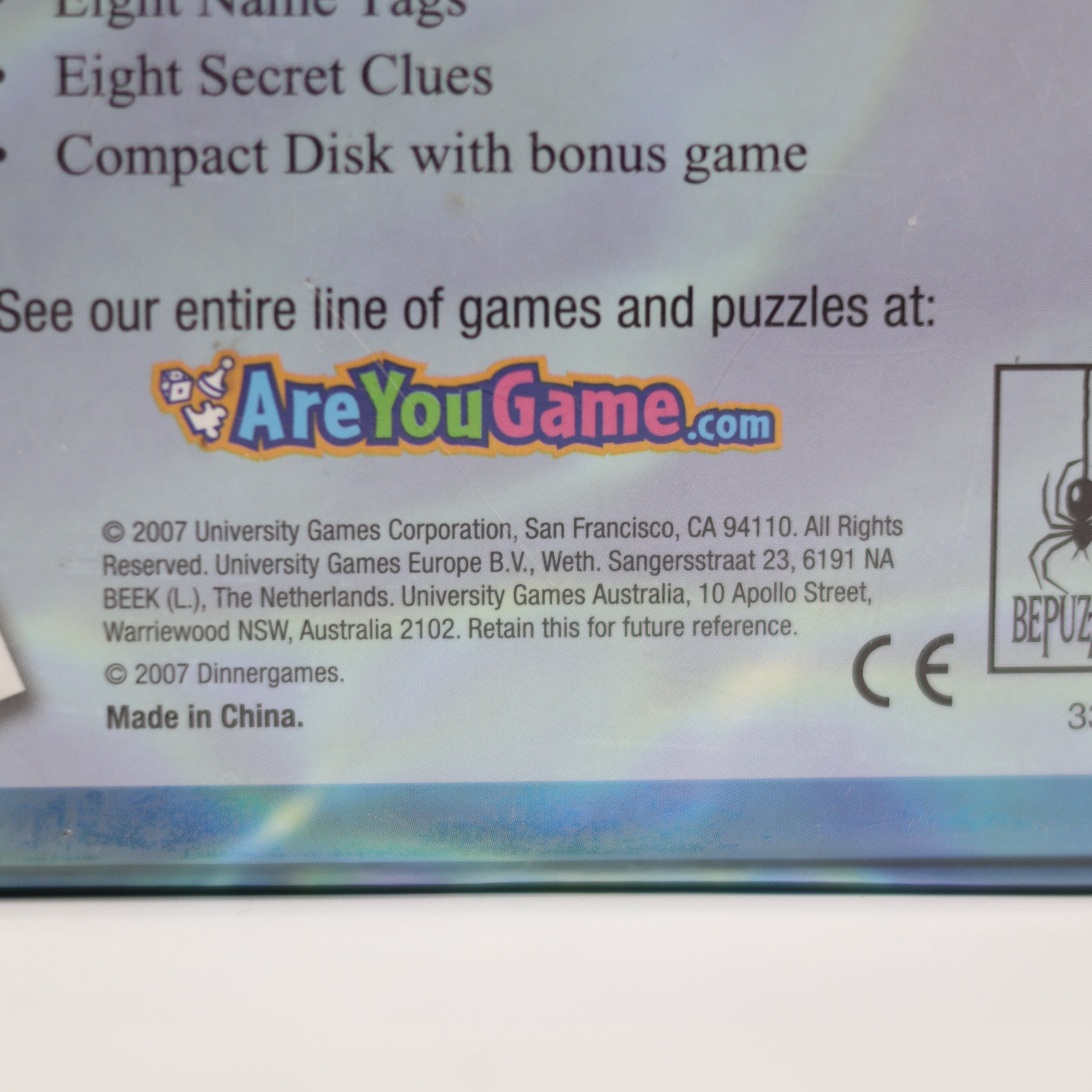 Back of a game packaging with branding and contact information.