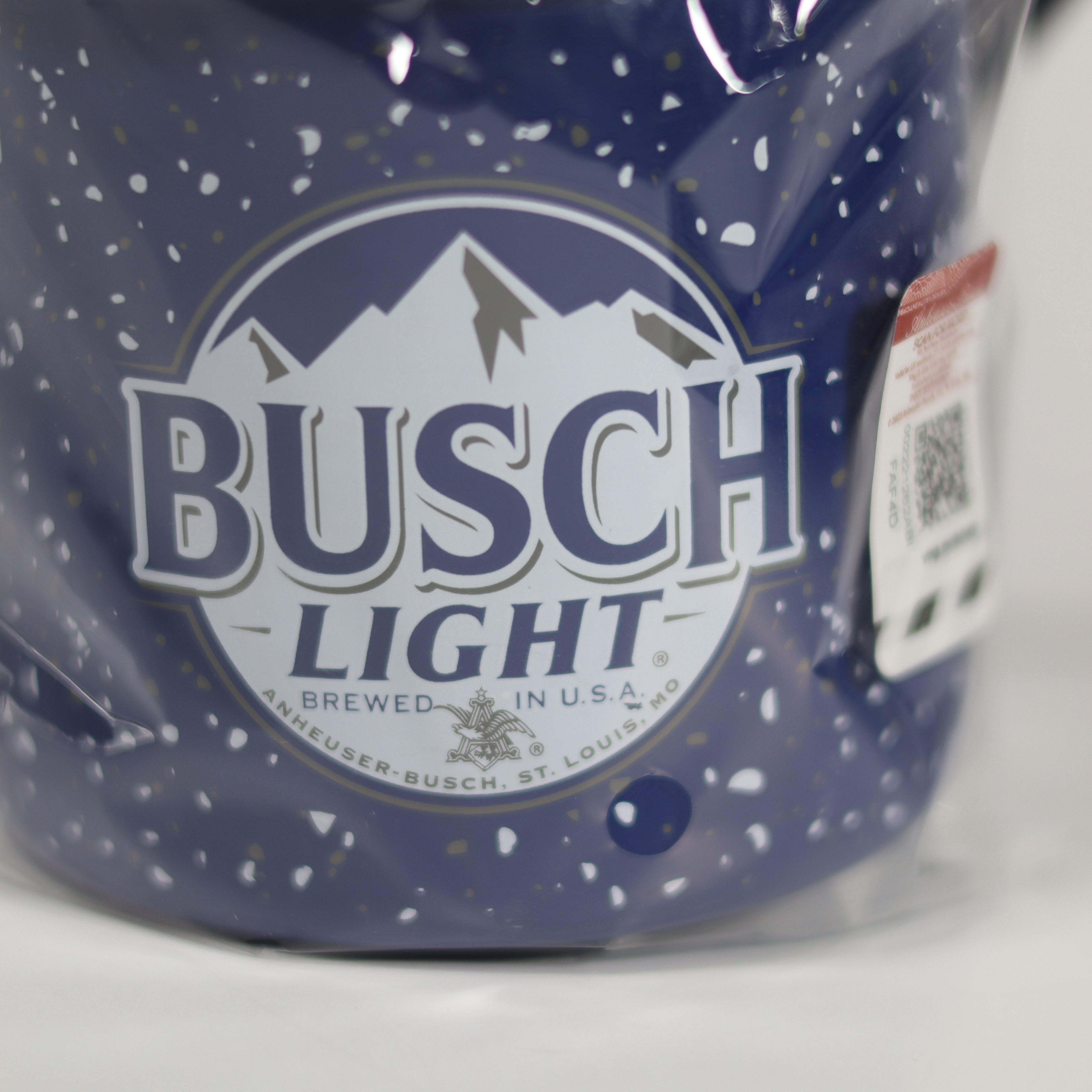 Close-up of a Busch Light label on a blue speckled mug.