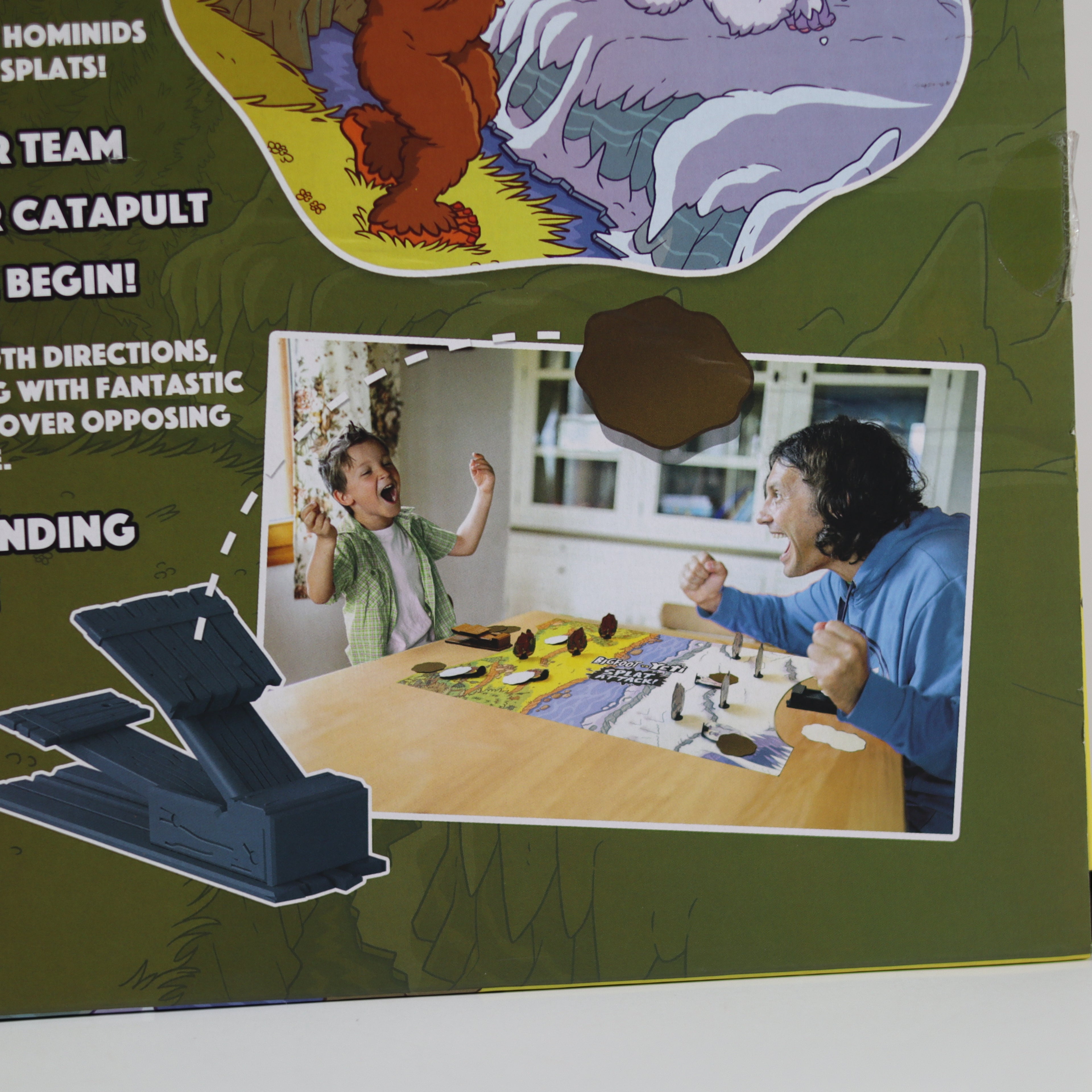 Product packaging with a child and adult playing a board game, featuring graphics of a bear and text.
