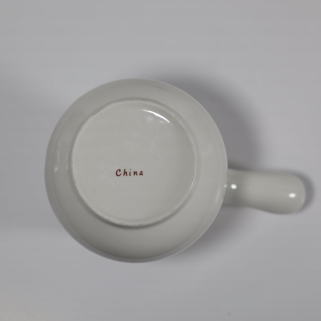 White ceramic mug with 'China' printed on the bottom on a light gray background