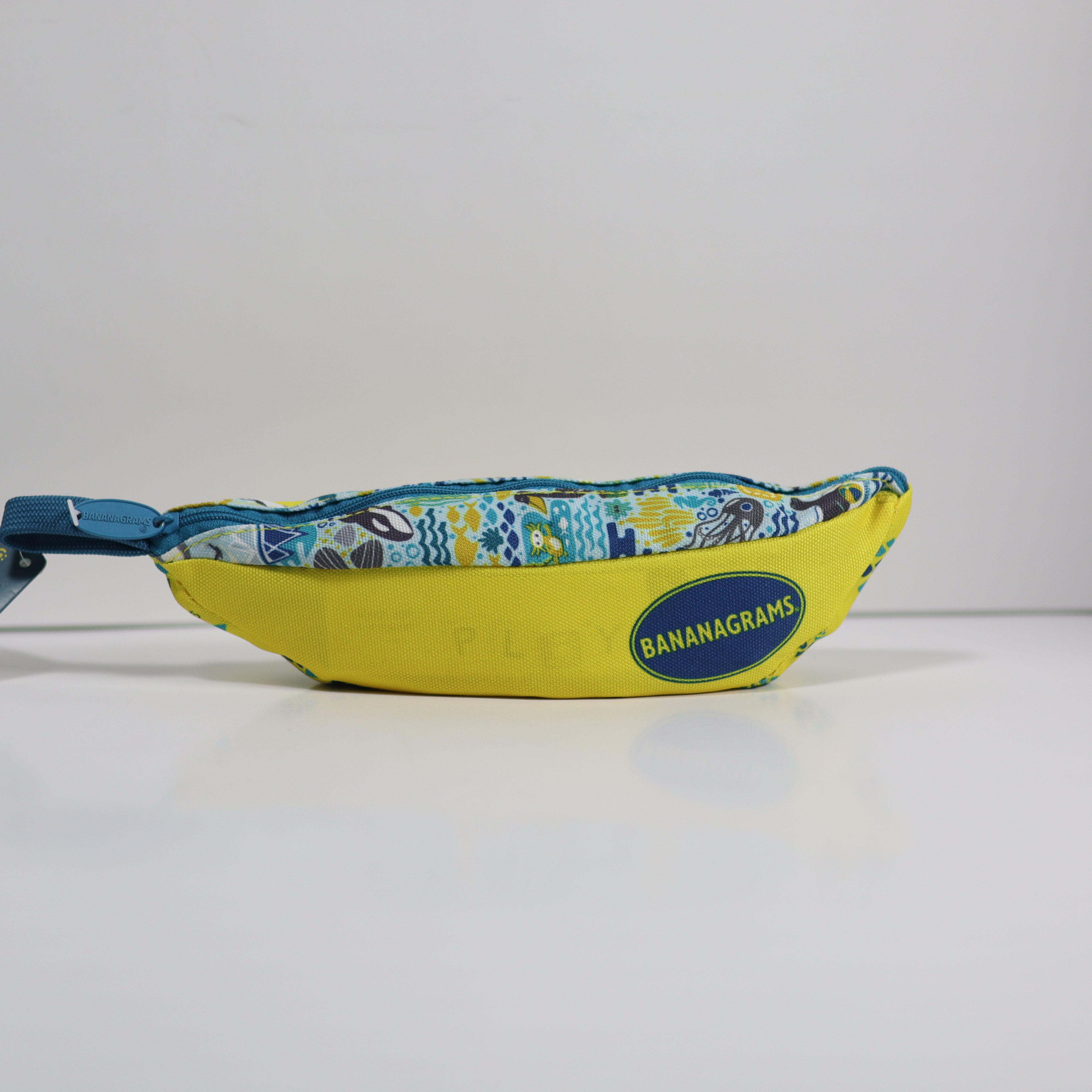 Yellow bag with blue zipper and 'Bananagrams' logo on a white background