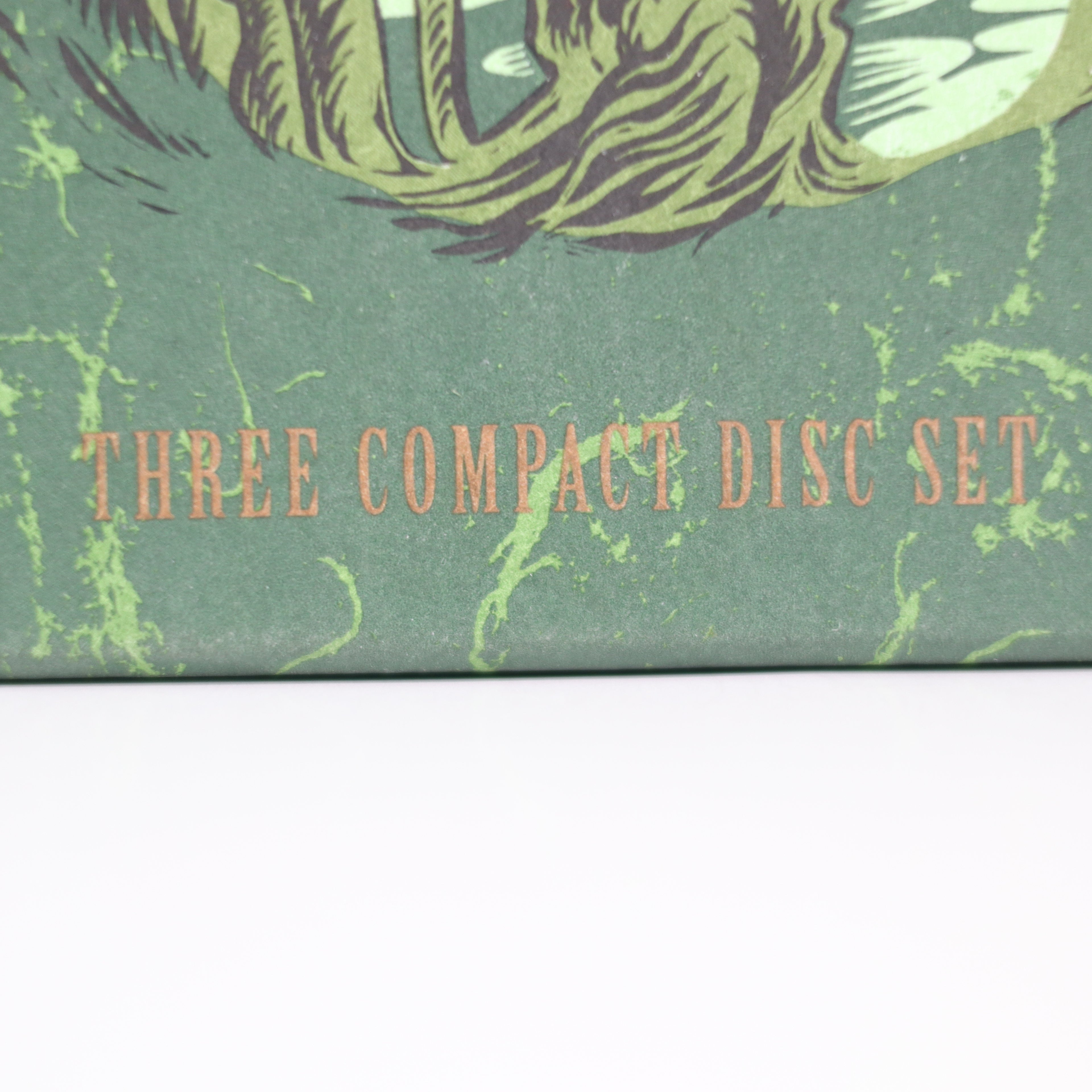 Compact disc set packaging with green design and text 'THREE COMPACT DISC SET'.
