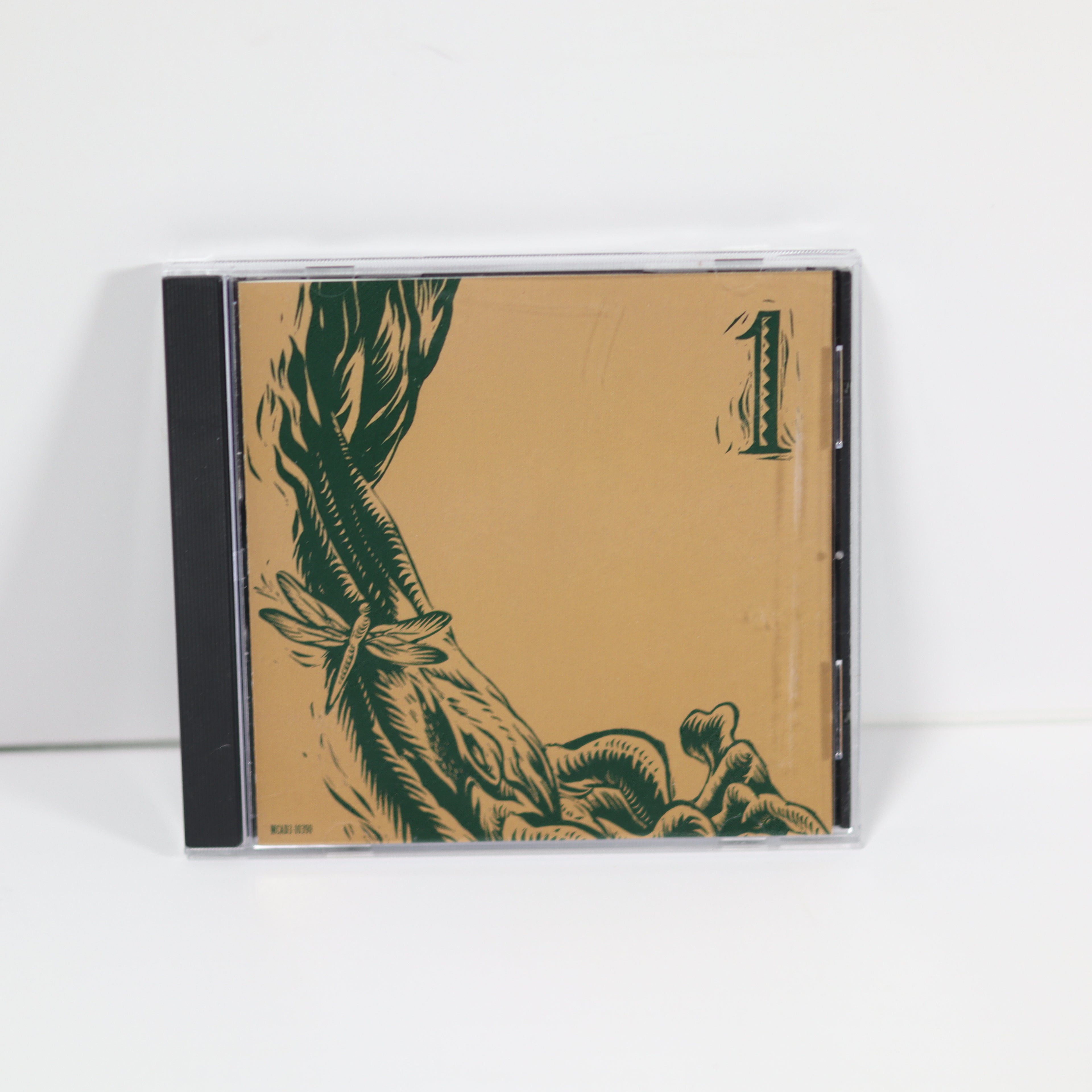 CD case with green illustrations on a beige background