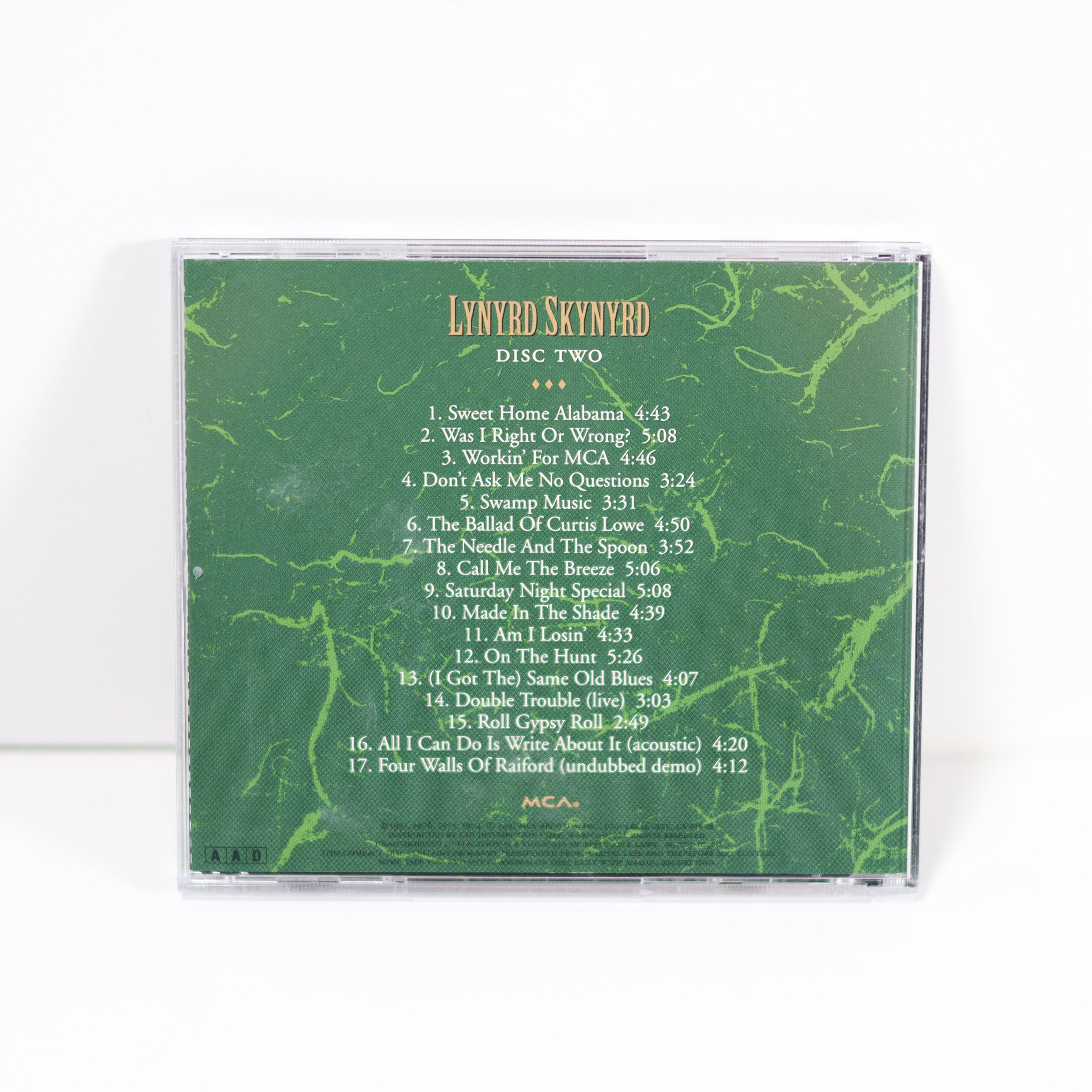 CD case with green marbled design and white text listing track names and times, on a white background.