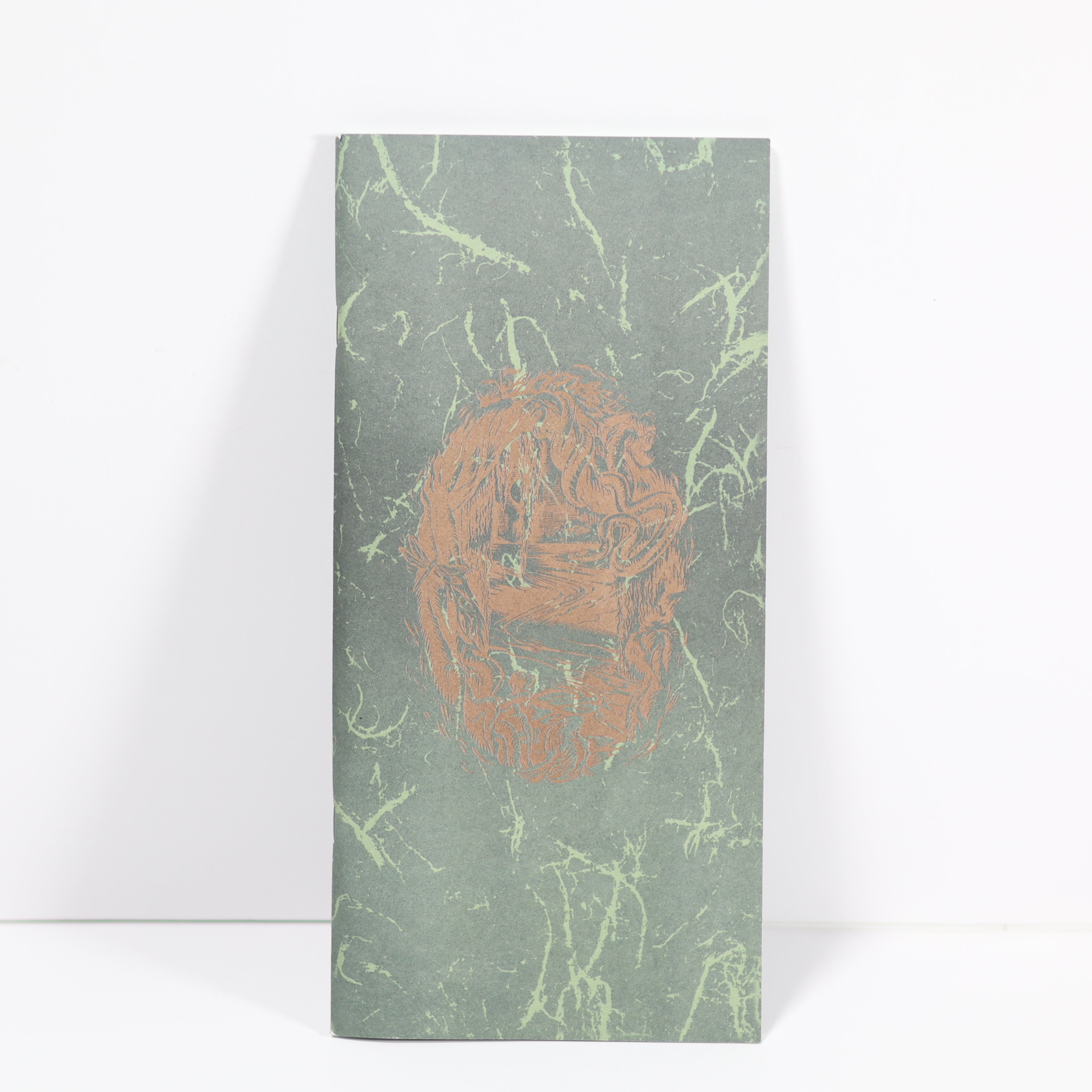 Notebook with a green marbled cover and a brown logo on a white background