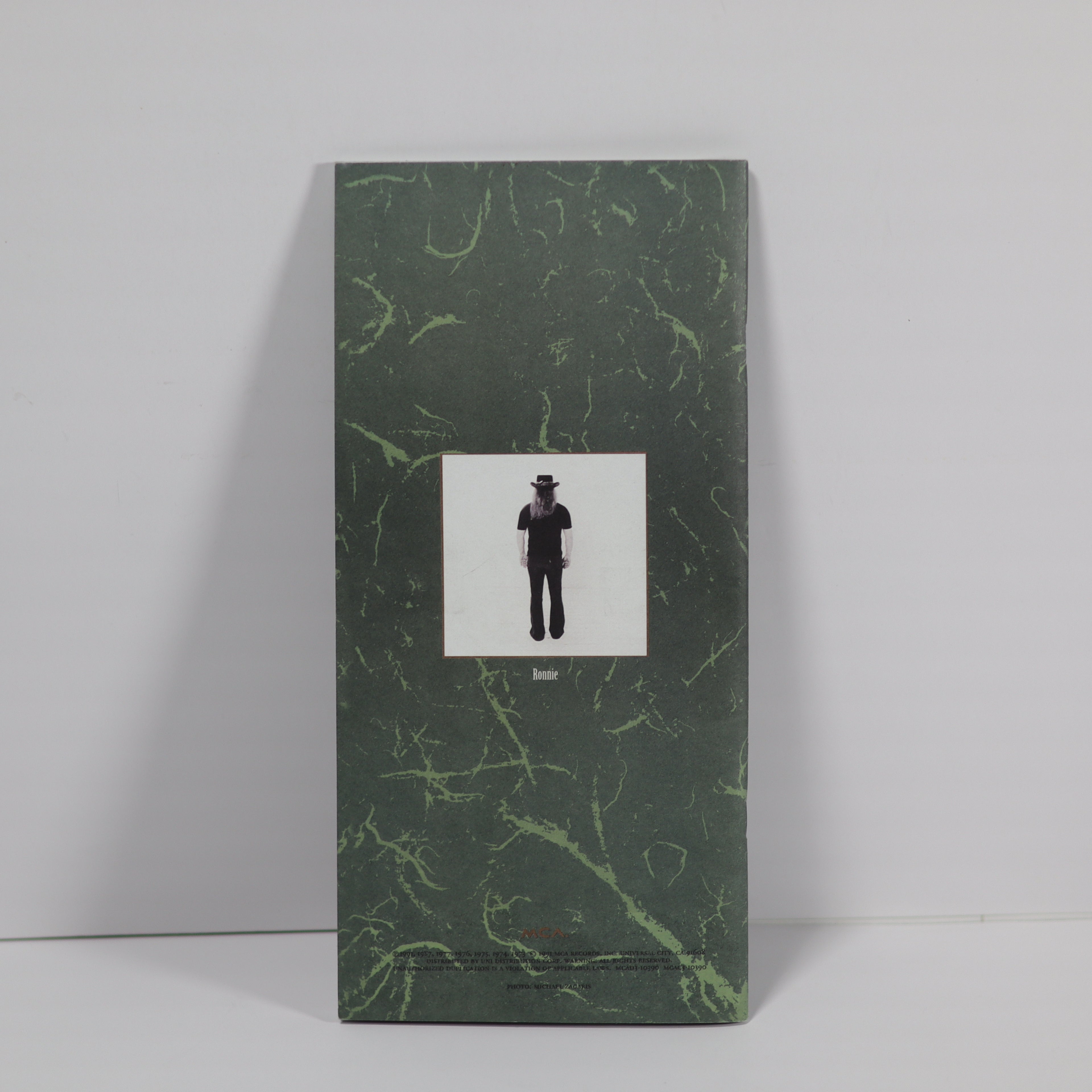 Green marbled book with a black and white illustration on a gray background