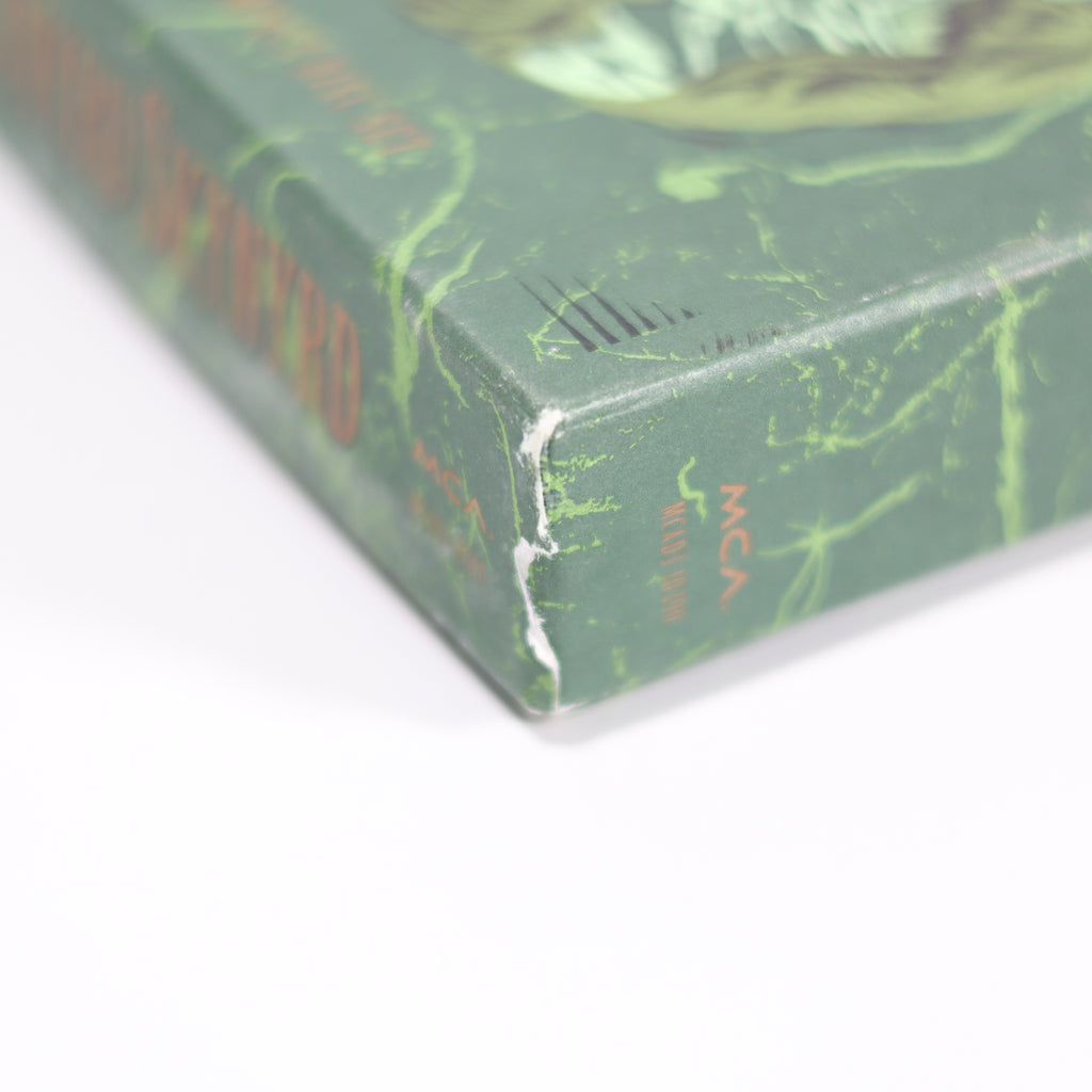 Close-up of a green book with marbled pages on a white background