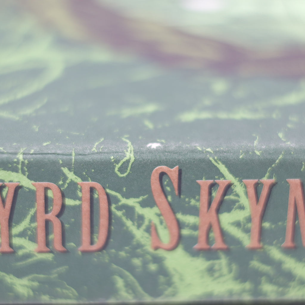 Close-up of a green book with 'YRDSKYN' embossed on it