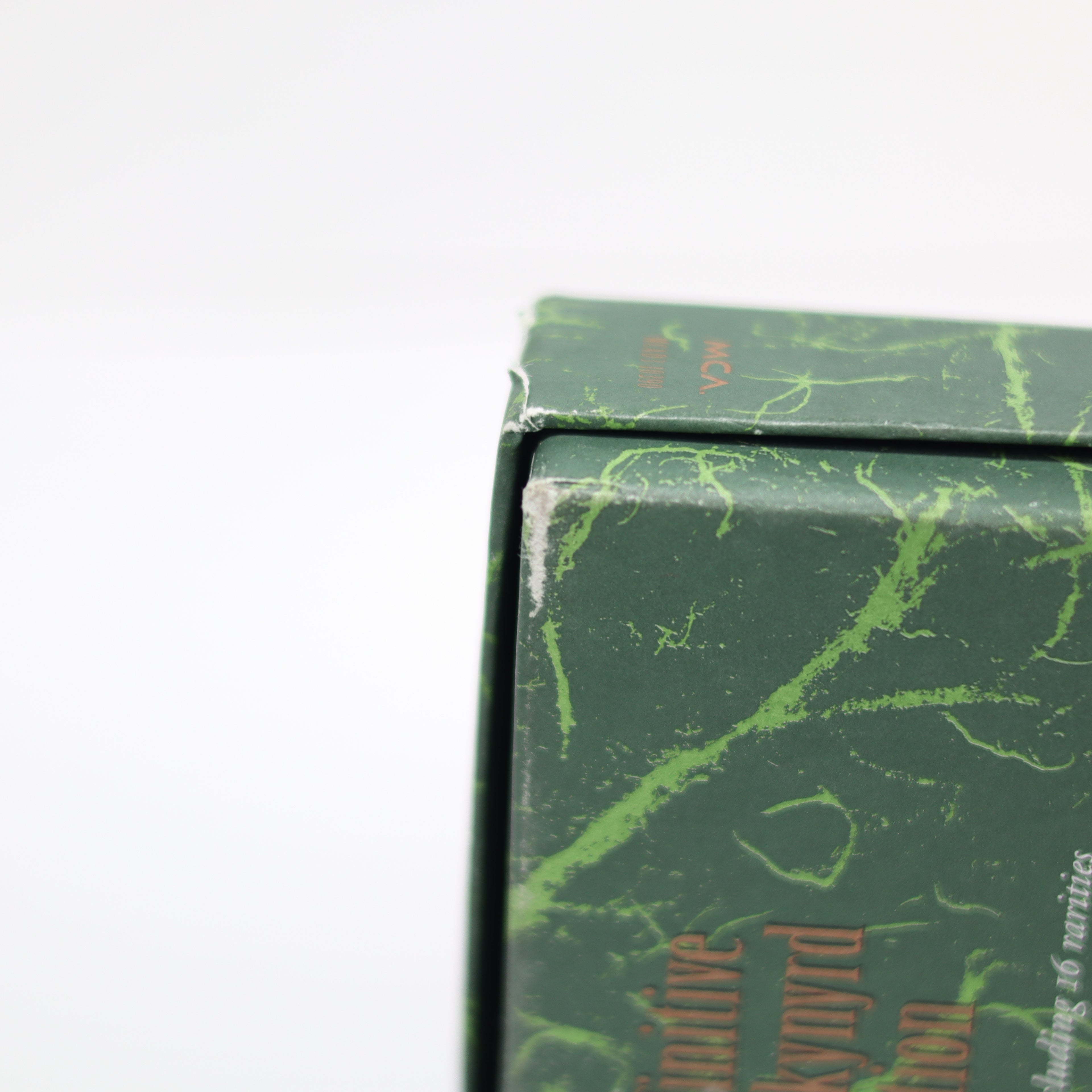 Close-up of a green book with marbled pages on a white background