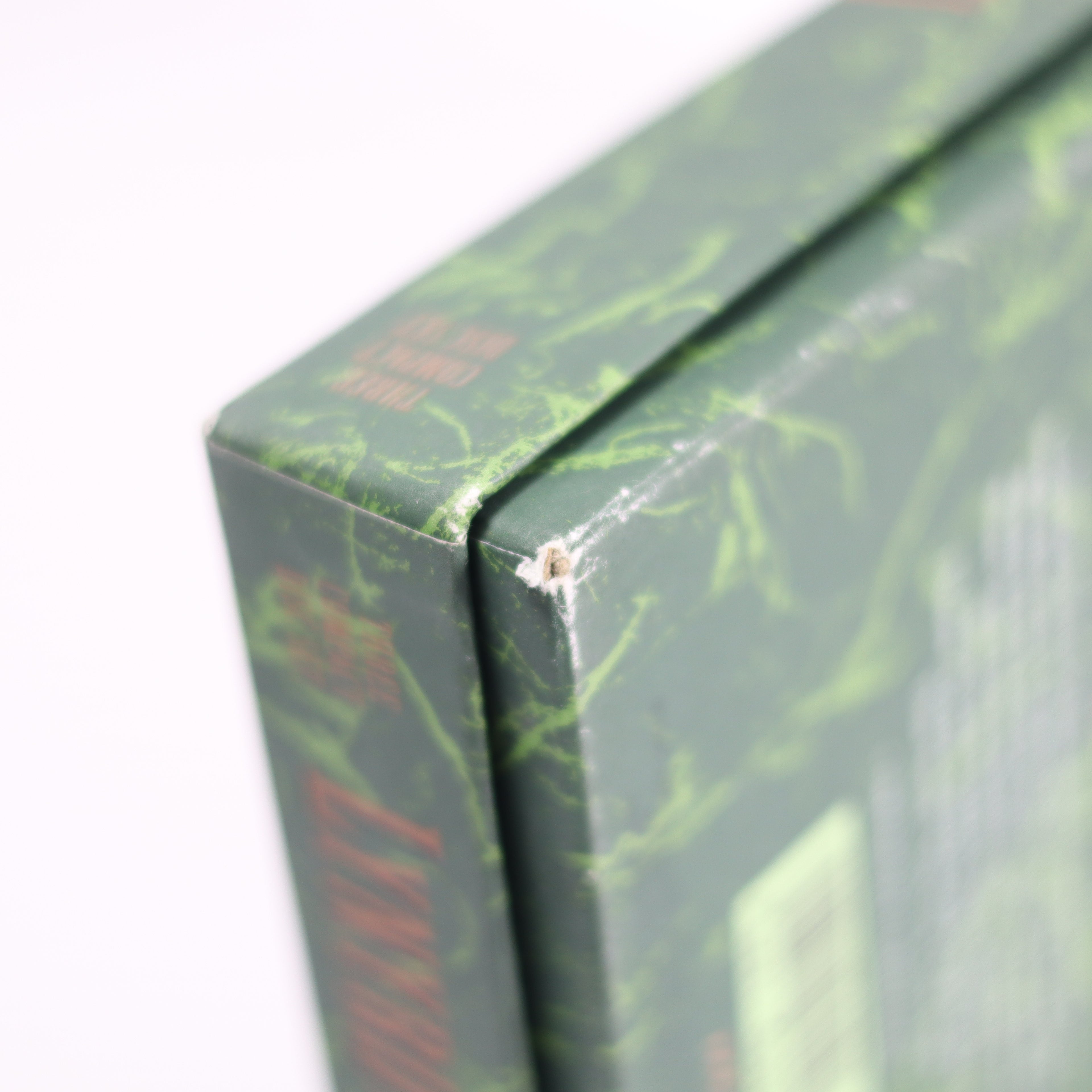 Close-up of a green marbled book with visible damage on the cover.