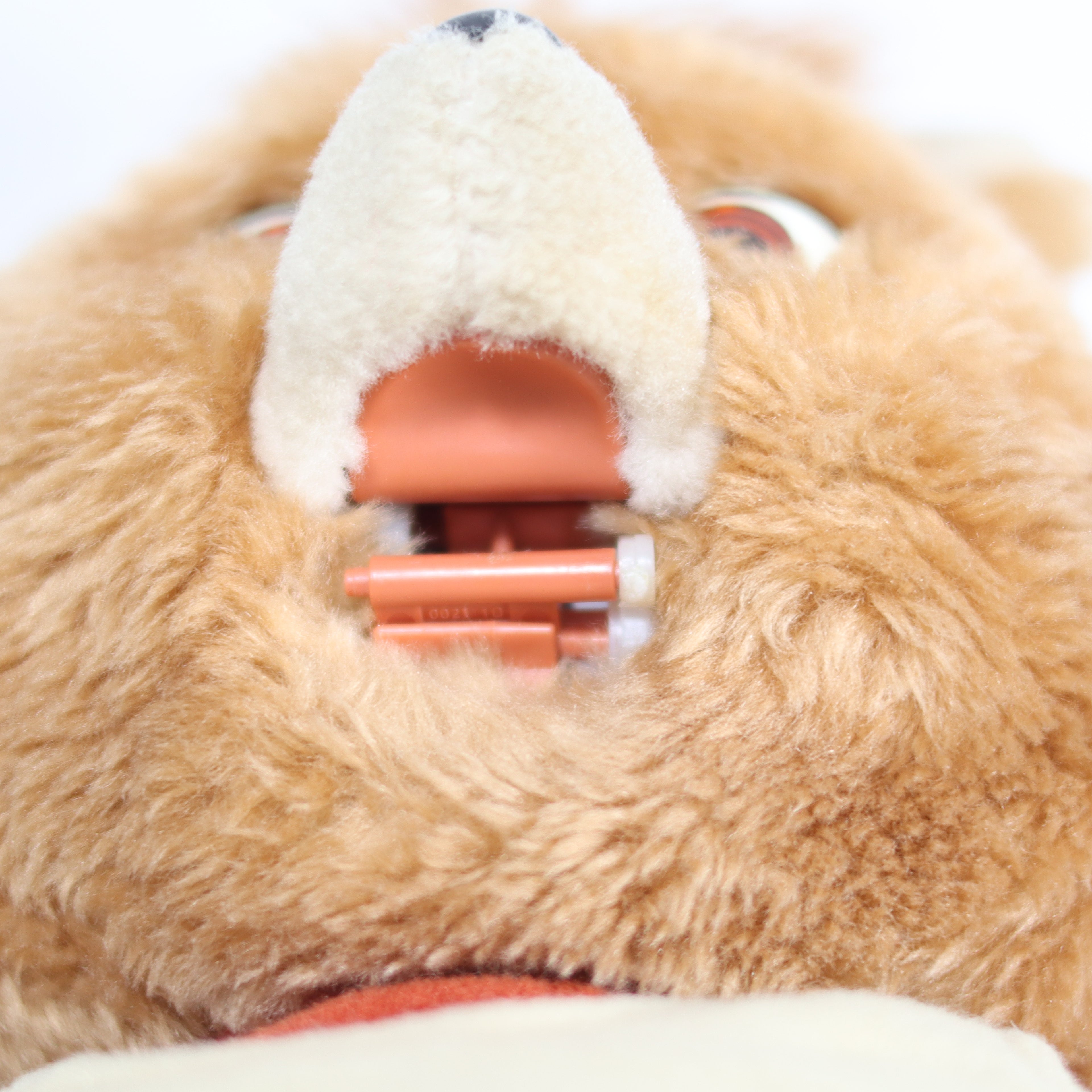 Close-up of a plush toy with a white muzzle and red interior.